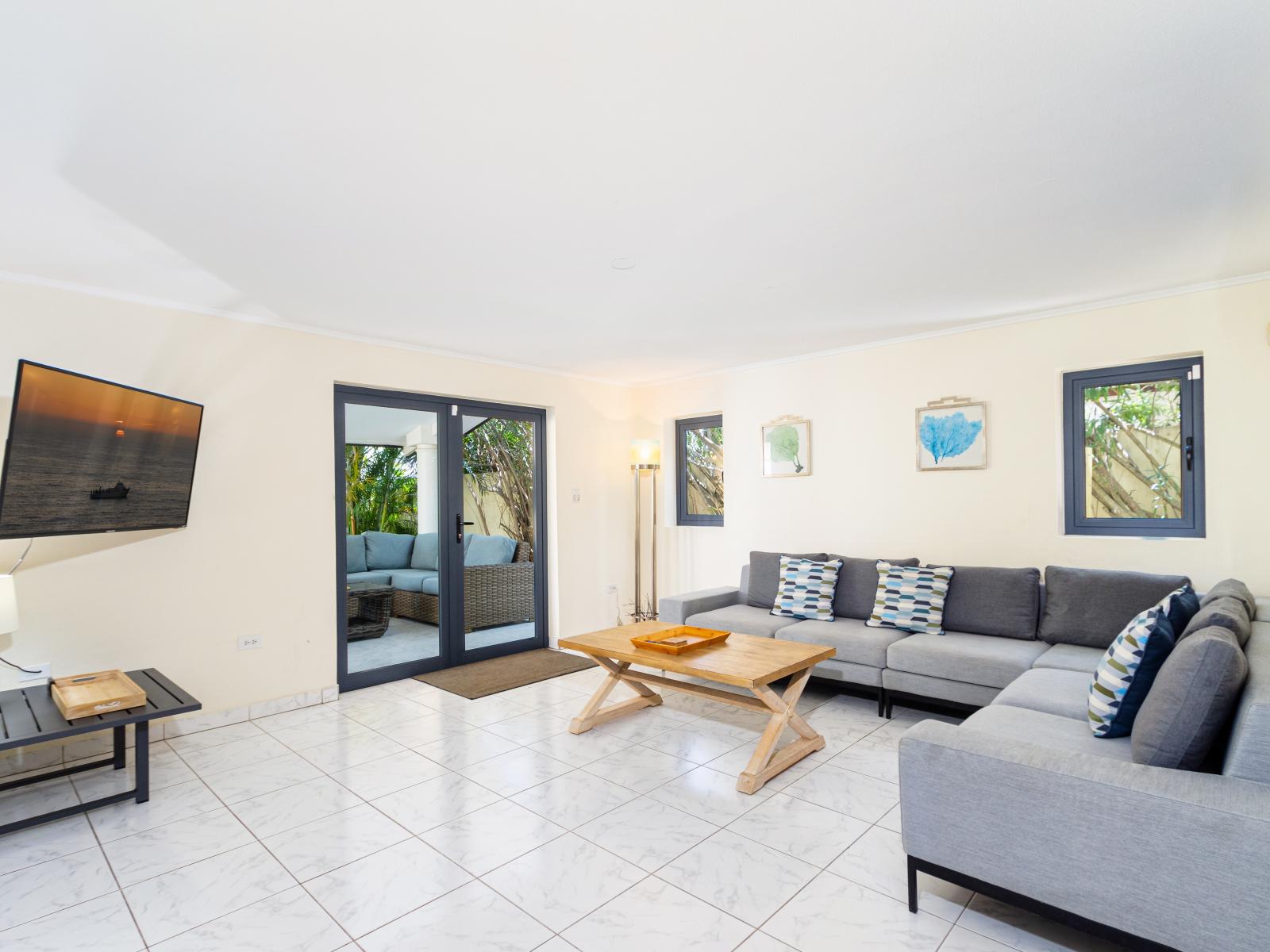 Ostentatious Living Area of the Villa in Noord Aruba - Smart TV and Netflix - Elegant Decor, adding sophistication - Comfy and Cozy Sofas - Spacious living room with glass sliding door access to the backyard