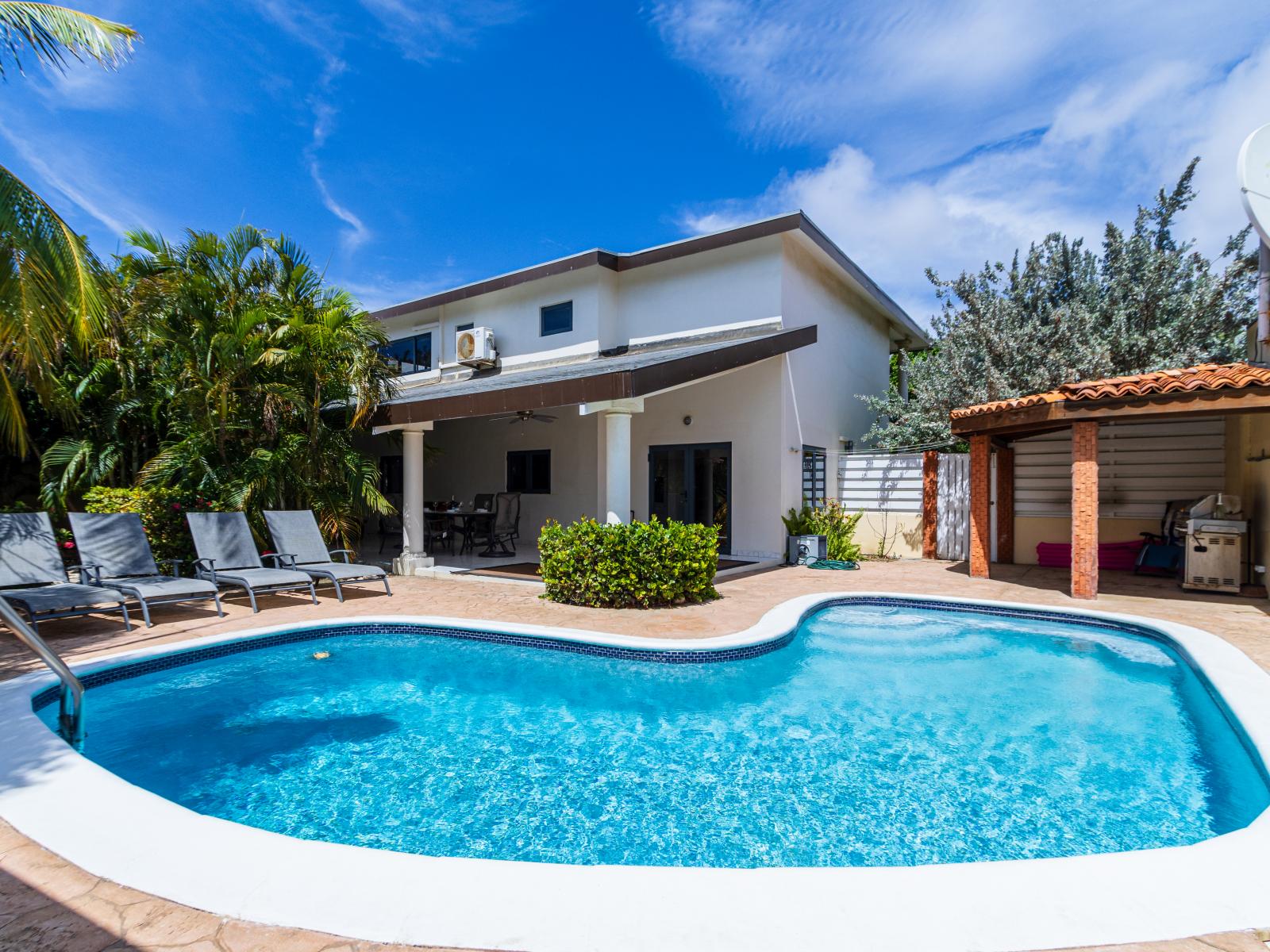 Luxury pool area of the Villa in Noord, Aruba - Lush and refreshing environment - Cozy beach chairs available - Beautifully sunbathed space makes the soul peaceful - Experience the comfort at the best