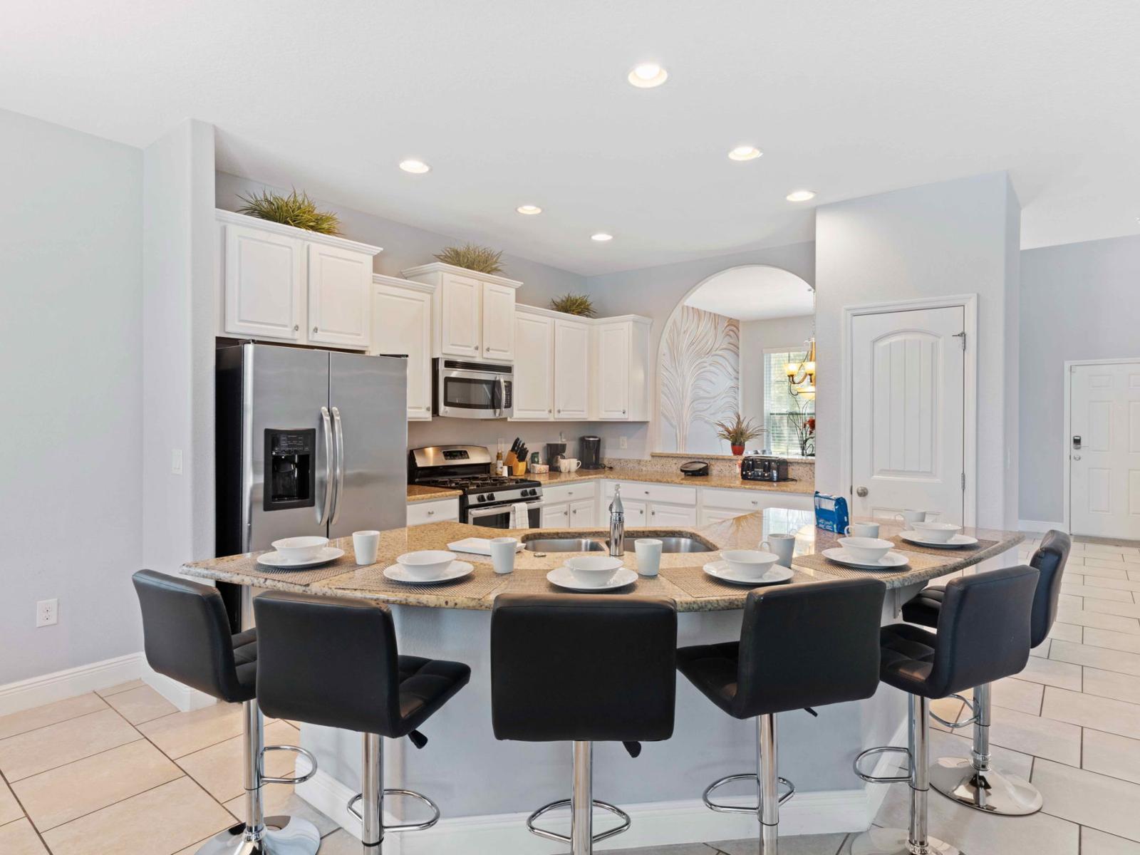 Lush kitchen of the home in Davenport Florida - Open-concept kitchen, fully furnished with stylish details - Breakfast bar with high chairs - Elegant and coordinated color palette for a cohesive look