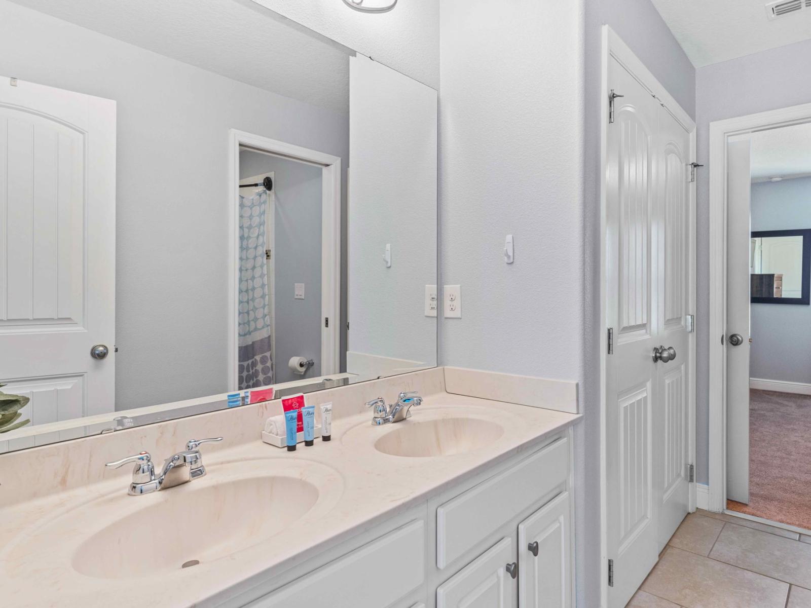 Sleek bathroom of the home in Davenport Florida - Enjoy the comfort of a walk-in shower  - Contemporary design meets functionality  - Chic dual vanity with large mirror and upscale lighting