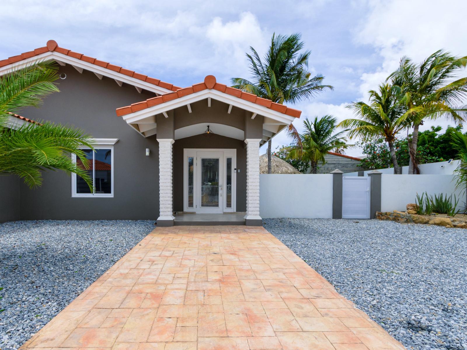 Inviting Entrance of the 3BR house in Noord Aruba - Palm trees and tropical plants enhance the vacation feel - Beautiful Home