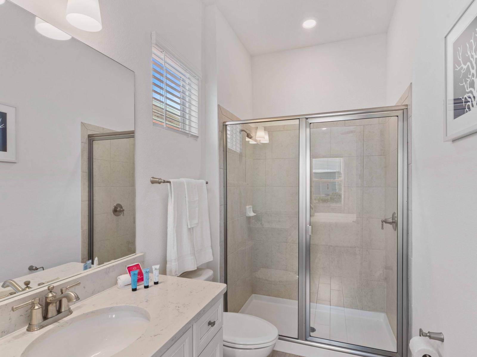 Luxe bathroom of the townhouse in Reunion Florida - Spacious walk-in shower stall - Elegant bathroom with luxurious fixtures and finishes - Chic design featuring a sleek vanity and upscale lighting