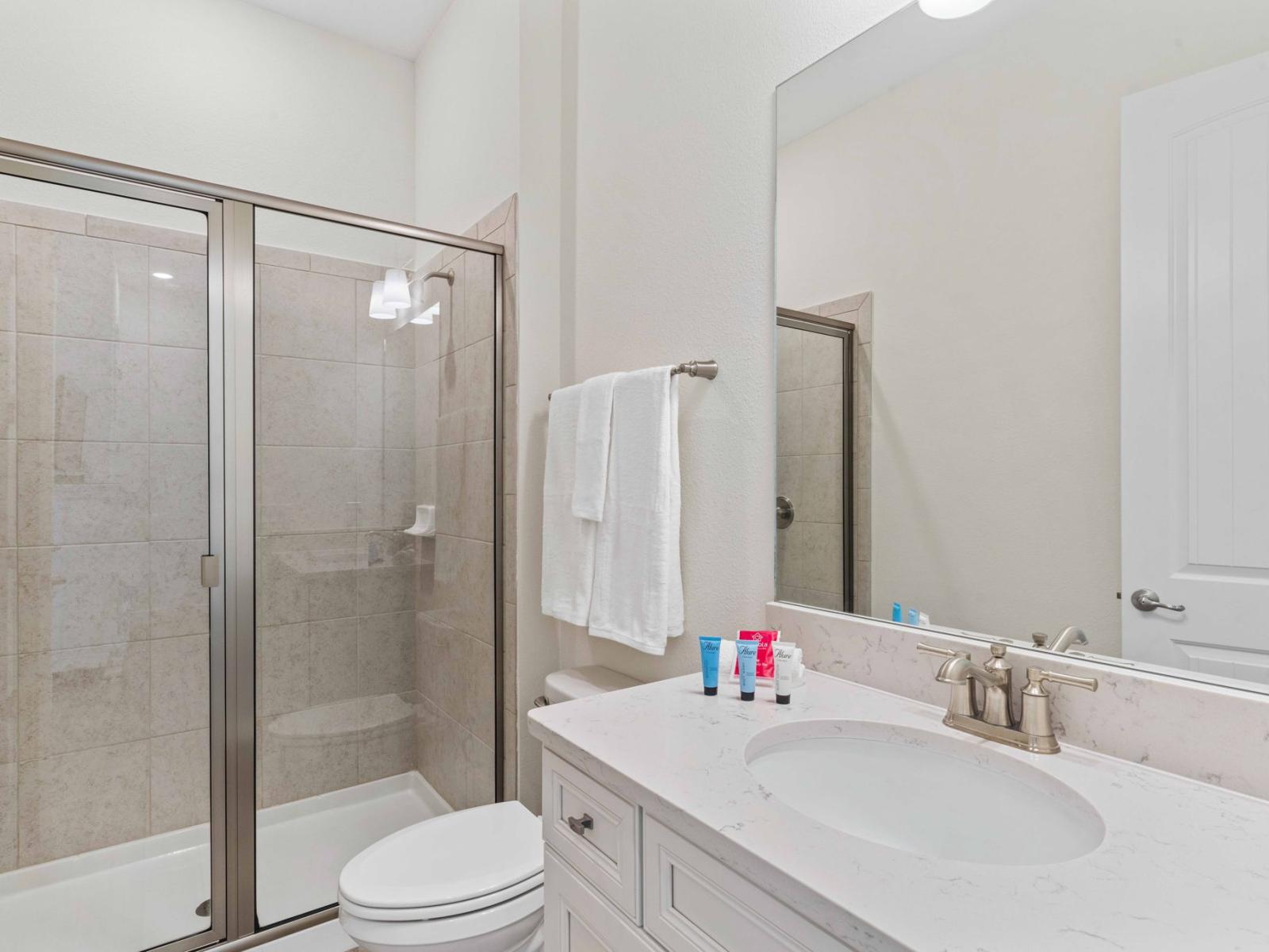 Chic bathroom of the townhouse in Reunion Florida - Chic design featuring a sleek vanity and upscale lighting - Seamless design featuring a glass-enclosed shower for a modern touch - Harmonious blend of classic and contemporary elements