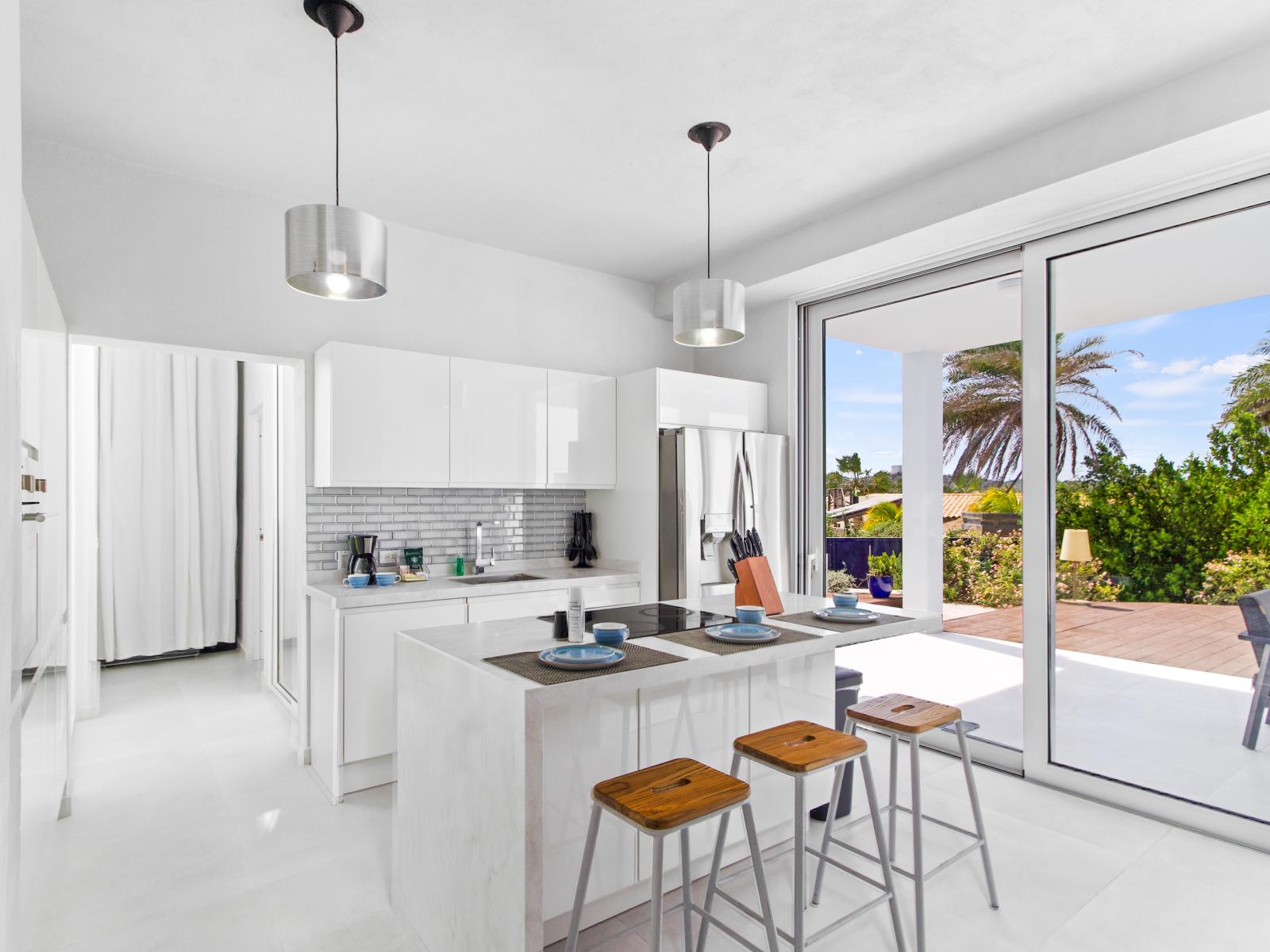 Graceful Kitchen of the vacation house in Santa Cruz Aruba - Fully equipped - Elegant and coordinated color palette for a cohesive look - Open concept connecting the kitchen to the dining and living area - Meal Bar and Bar chairs