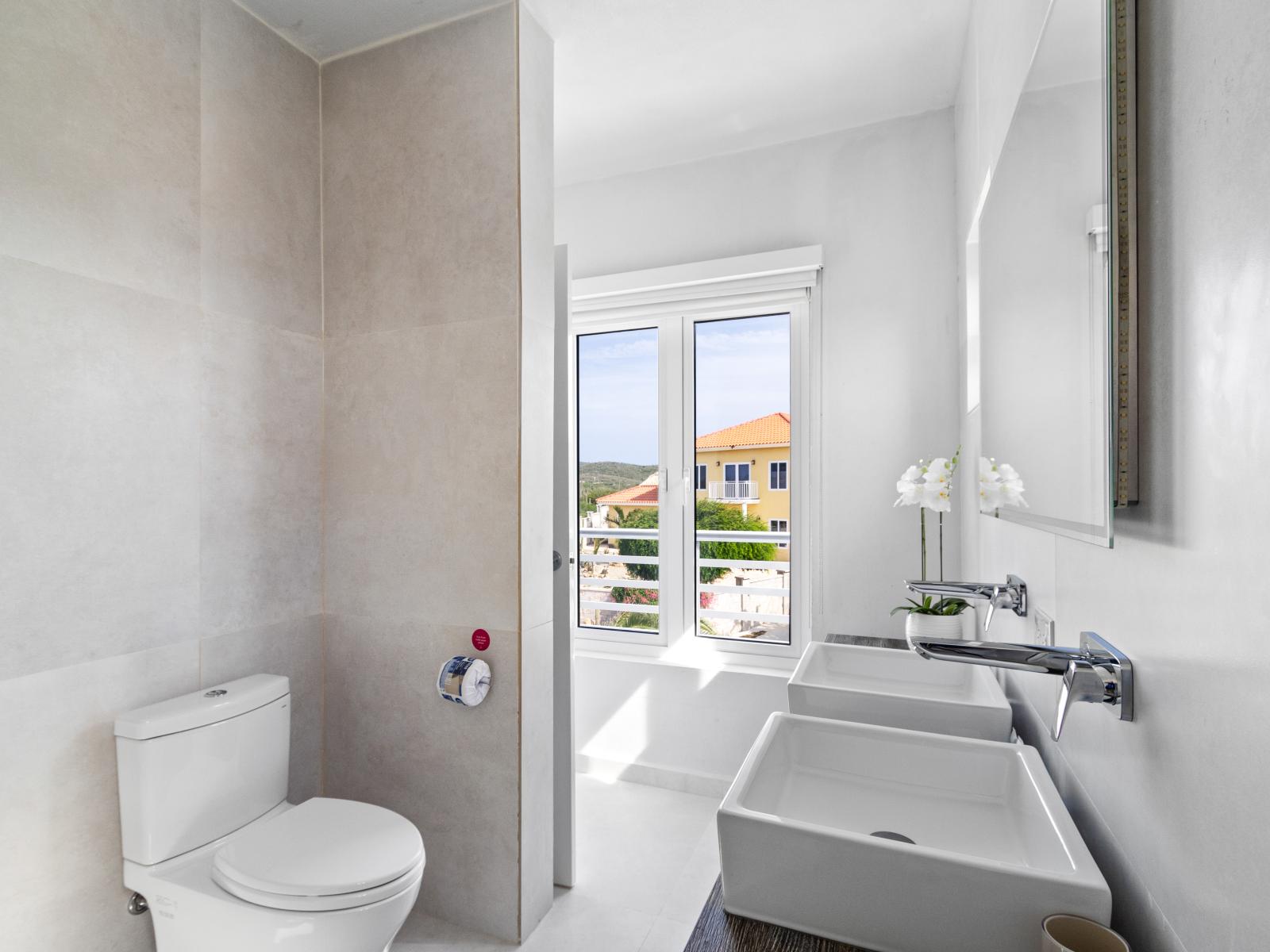 Lush Bathroom of the vacation home in Aruba - Offers double sinks - Inviting bathroom with a soothing color palette for a tranquil feel - Understated elegance with clean lines and refined details