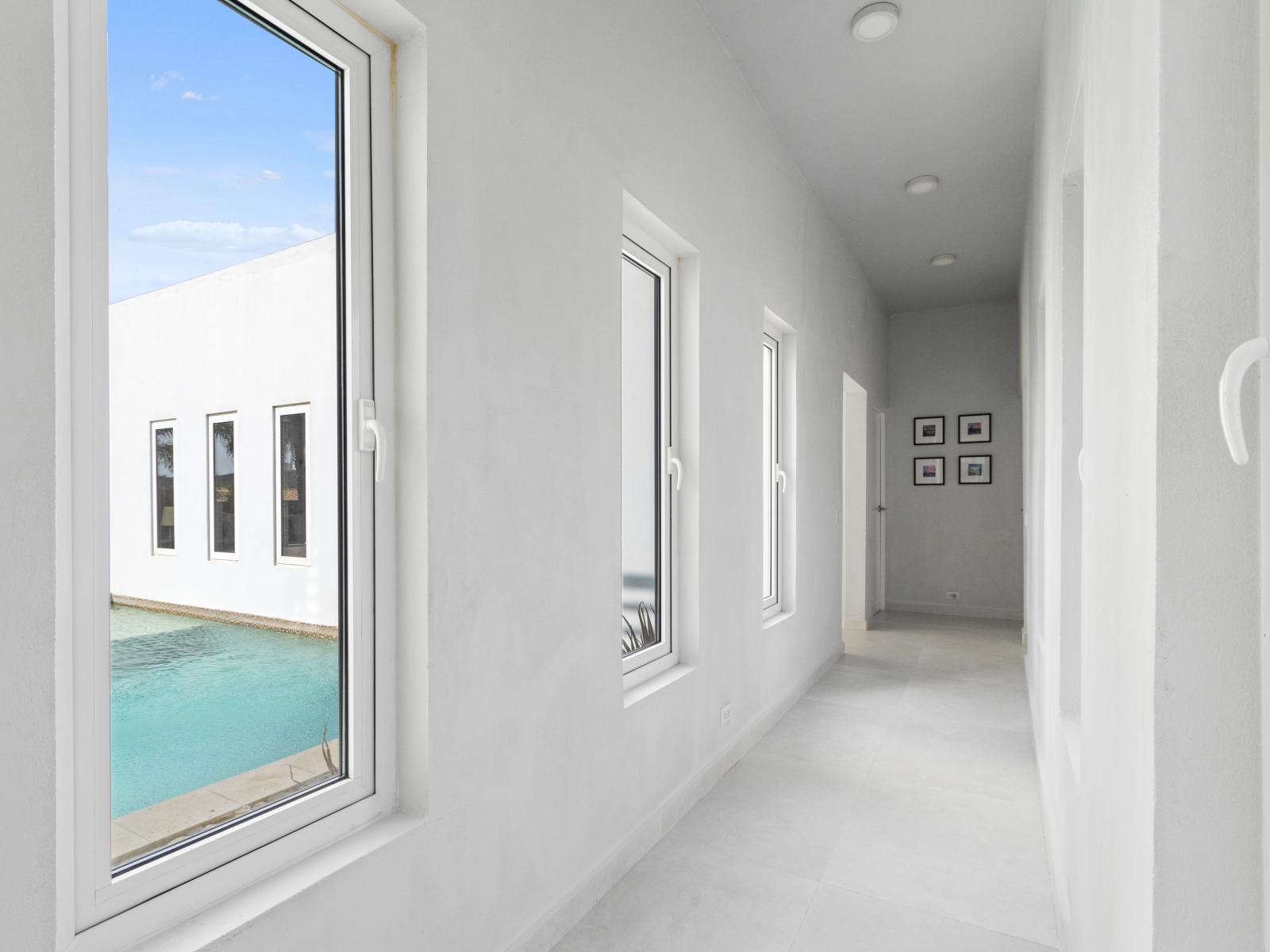 Walk down the bright, inviting hallway to your rooms, enjoying picturesque views of the shimmering pool along the way.