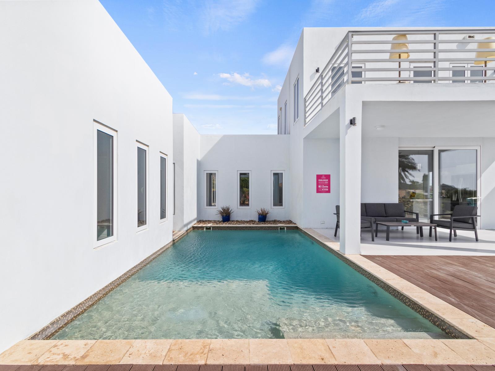 Discover our serene pool area, designed for ultimate relaxation with lush greenery and comfortable lounge chairs—an oasis to unwind and escape.