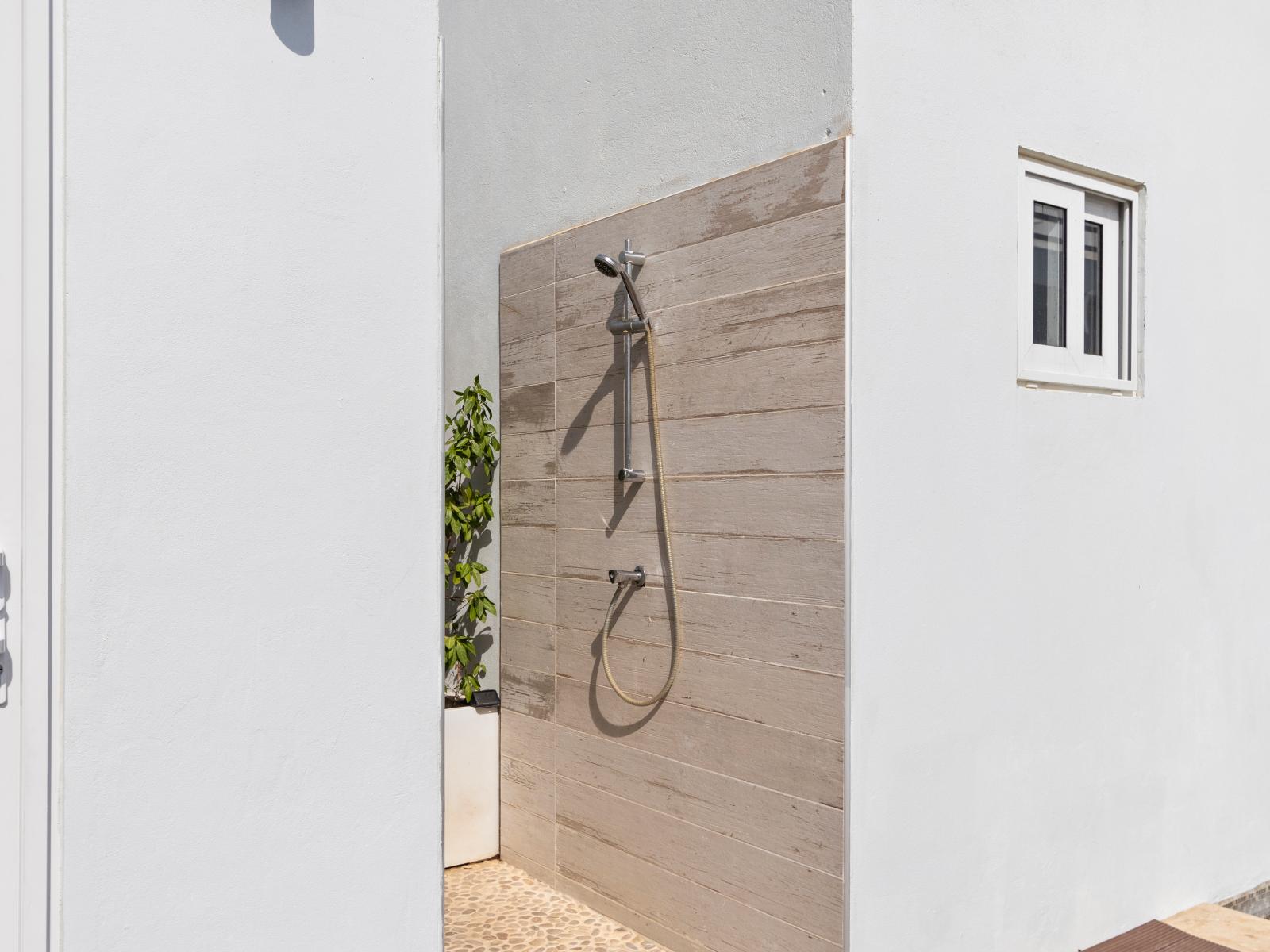 Escape to tranquility with our refreshing open-air outdoor shower, surrounded by lush greenery and fresh air, perfect for rejuvenating in a natural setting.