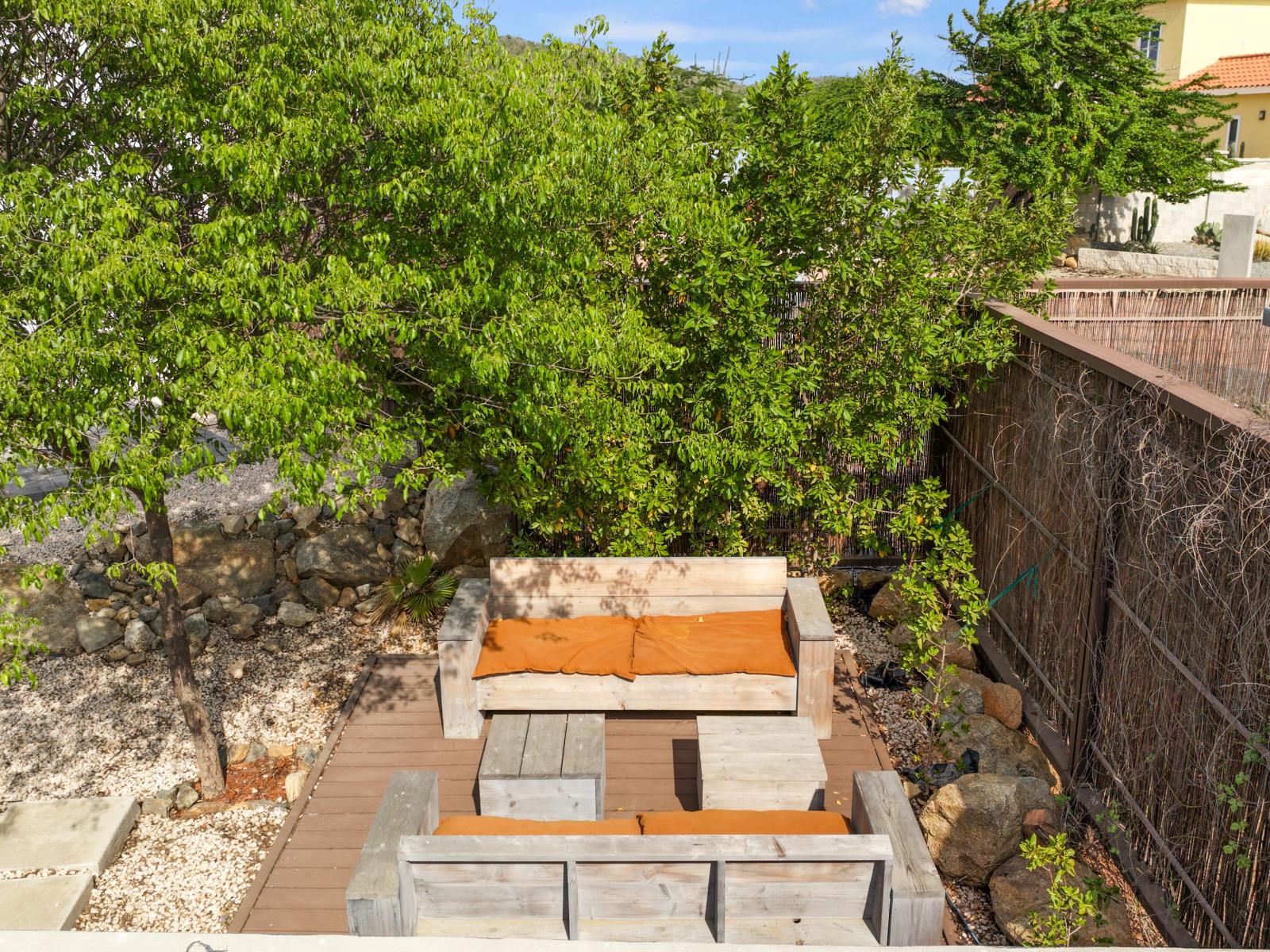 Outdoor relaxation oasis_ Comfortable lounge chairs beneath the shade of a tree, inviting you to unwind_