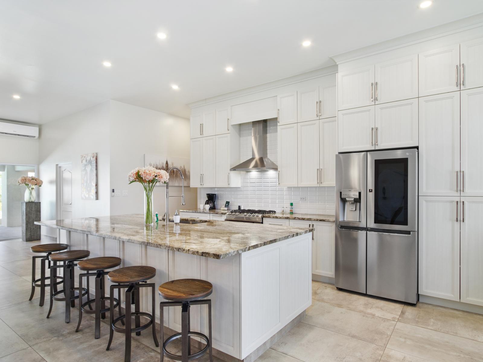 Imposing Kitchen of the Villa in Noord Aruba - Modern kitchen with sleek, stainless steel appliances - Integrated appliances for a seamless and stylish appearance - Smart use of space with versatile storage solutions