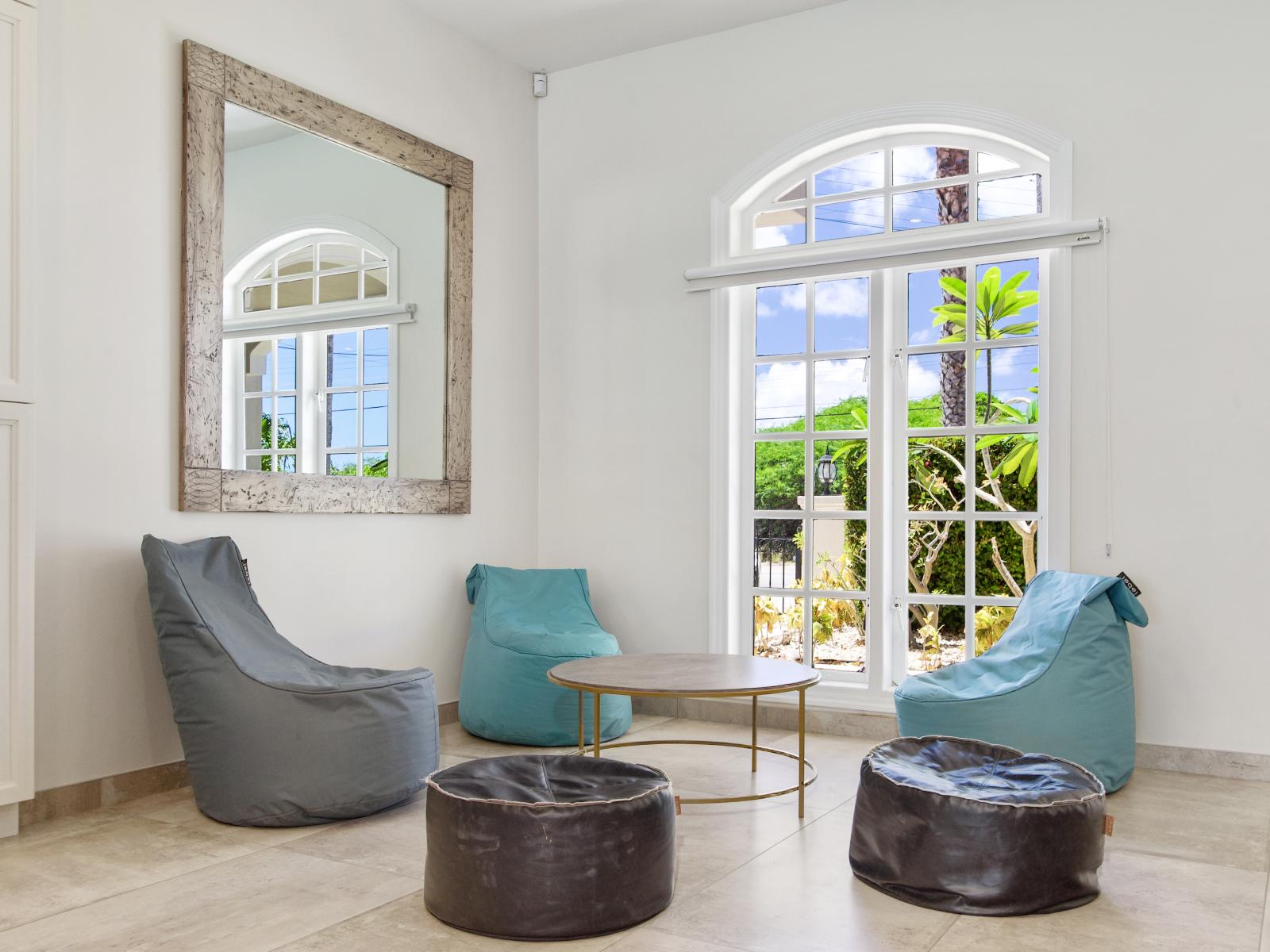 Cozy Sitting Area of the Villa in Noord Aruba - Cozy seating area conducive to relaxation and socializing - Large Windows and mirror - Lush Outside Views