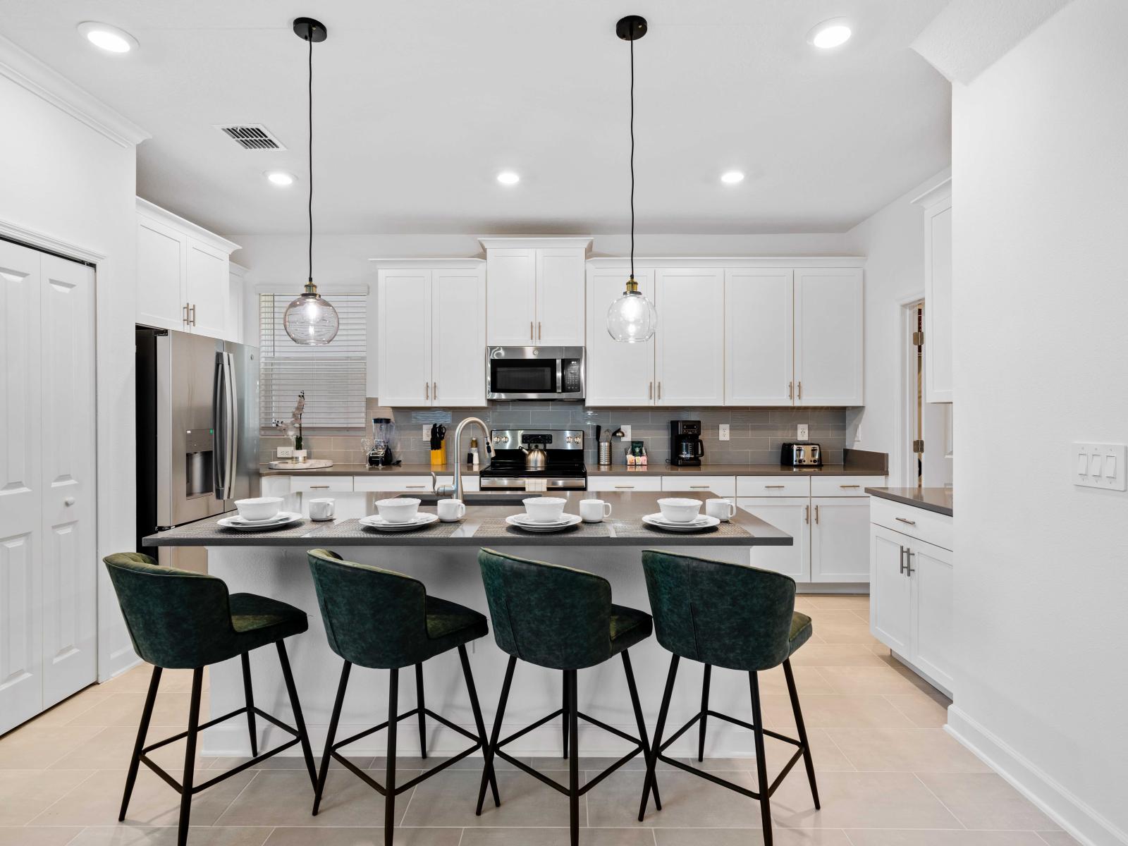 Roomy Kitchen of the Home in Davenport Florida - Stainless Steel Appliances - Availability of all kitchen accessories - Elegant lighting - Sufficient space to walk and work according to your ease - High chairs and Breakfast bar