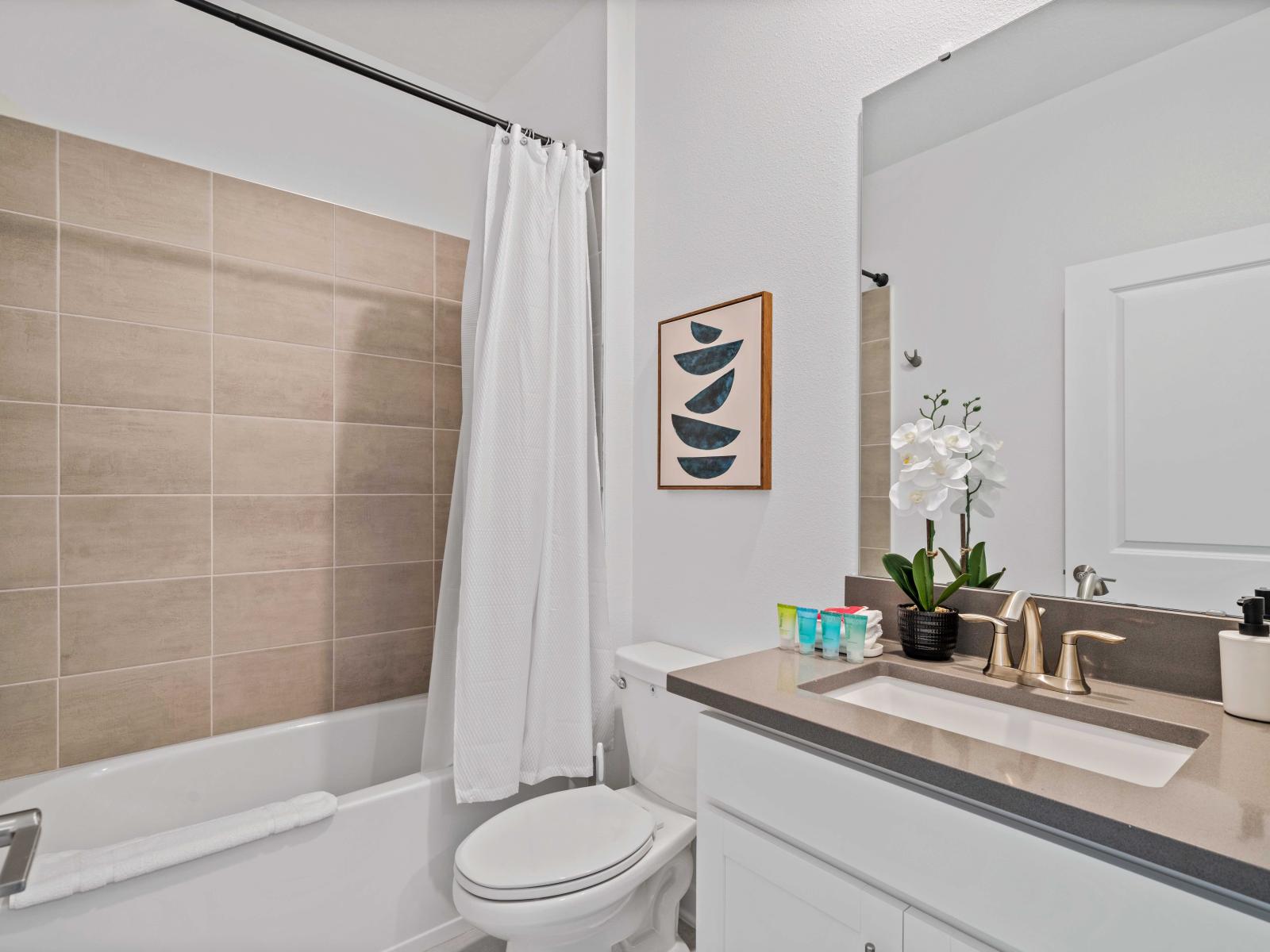 Elegant Bathroom of the Home in Davenport Florida - Bathtub and a shower combo - Luxe vanity with Large Mirror - Elegant bathroom with luxurious fixtures and finishes