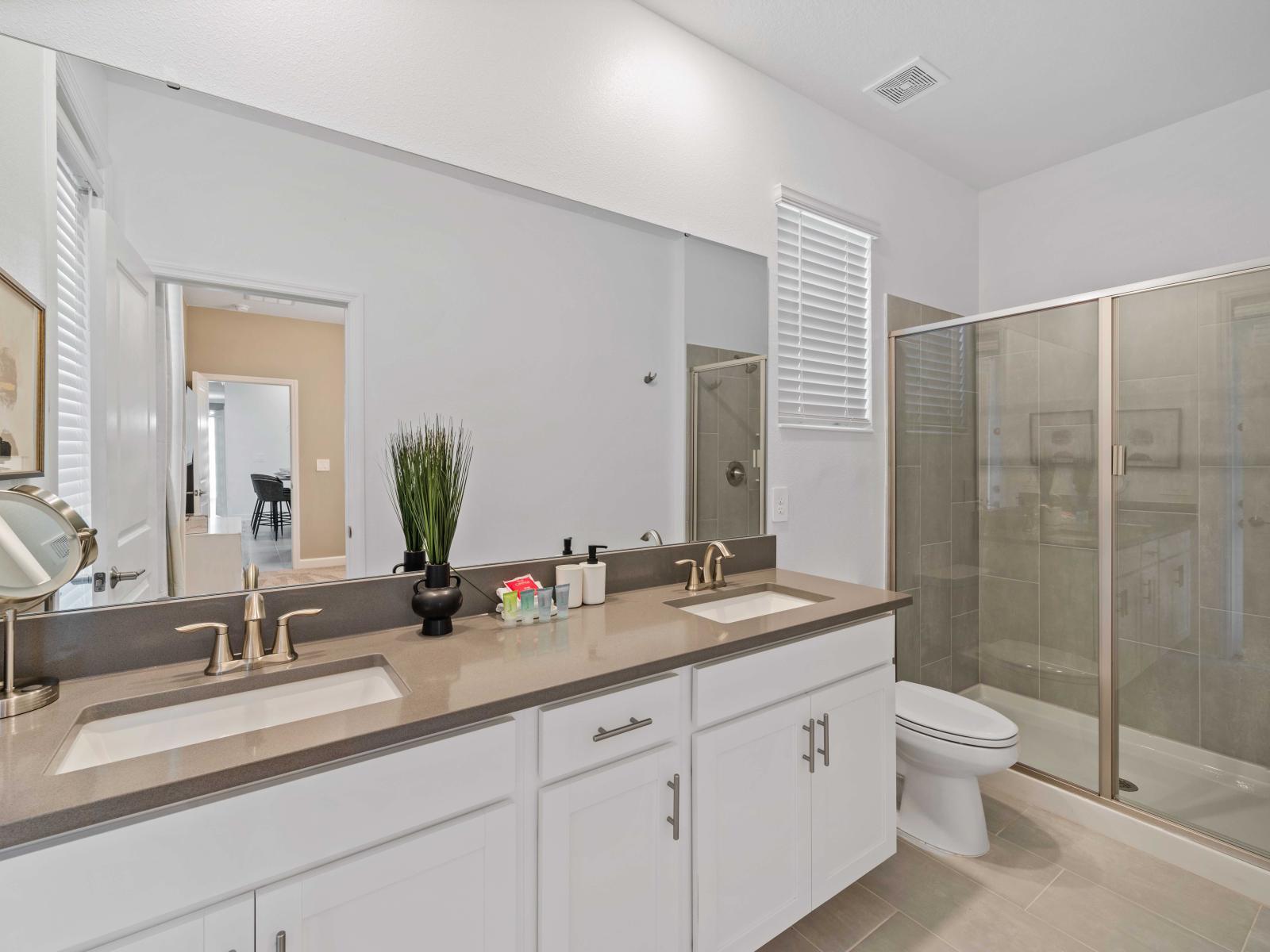 Luxury Bathroom of the Home in Davenport Florida - Featuring a decadent and  modern walk-in shower  - Lavish dual vanity with large mirror