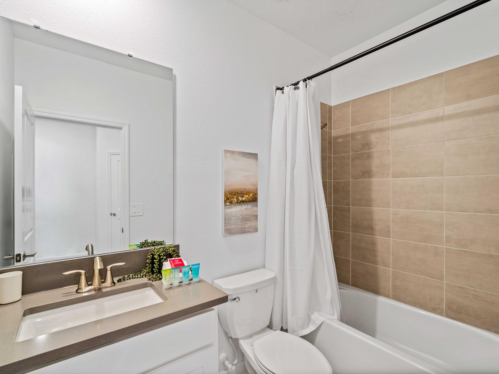 Upscale Bathroom of the Home in Davenport Florida - Chic design featuring a sleek vanity and upscale lighting - Seamless design featuring shower and bathtub combo - Layout offering a sense of luxury and comfort