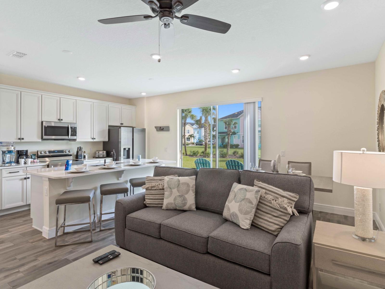 Elegant living area of the cottage in Kissimmee Florida - Modern elegance meets cozy comfort - Explore the perfect fusion of kitchen and living area - Easy access to outdoors with seating