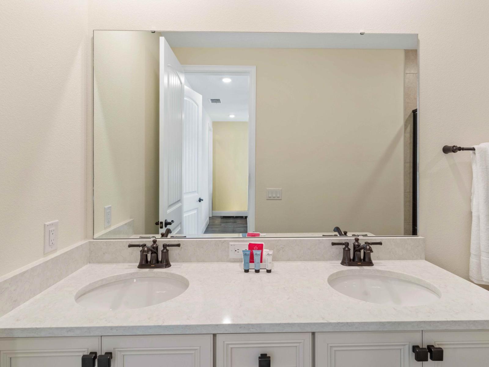 Lush bathroom of the cottage in Kissimmee Florida - Offers double vanity and large mirror - Inviting bathroom with a soothing color palette for a tranquil feel - Understated elegance with clean lines and refined details