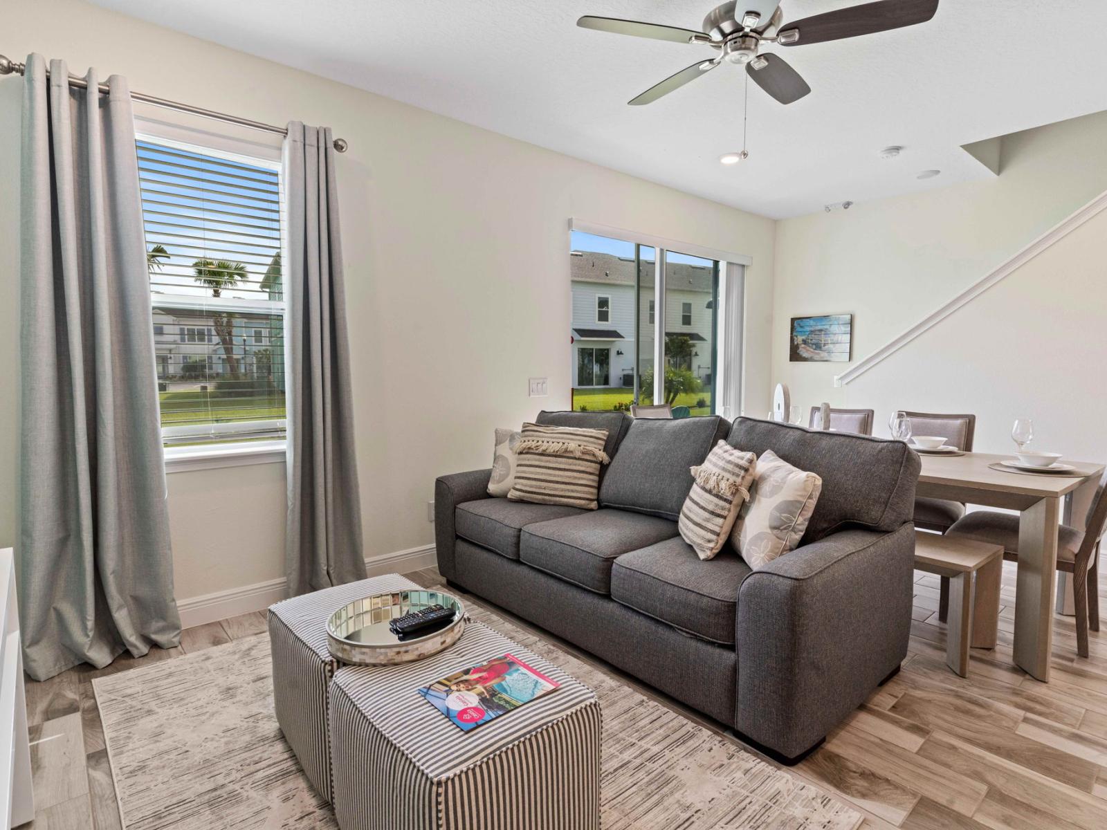 Alluring living area of the cottage in Kissimmee Florida - Discover the epitome of comfort with plush sofas - Natural light floods the room, enhancing its warmth and inviting atmosphere - Premium quality fixtures and fittings