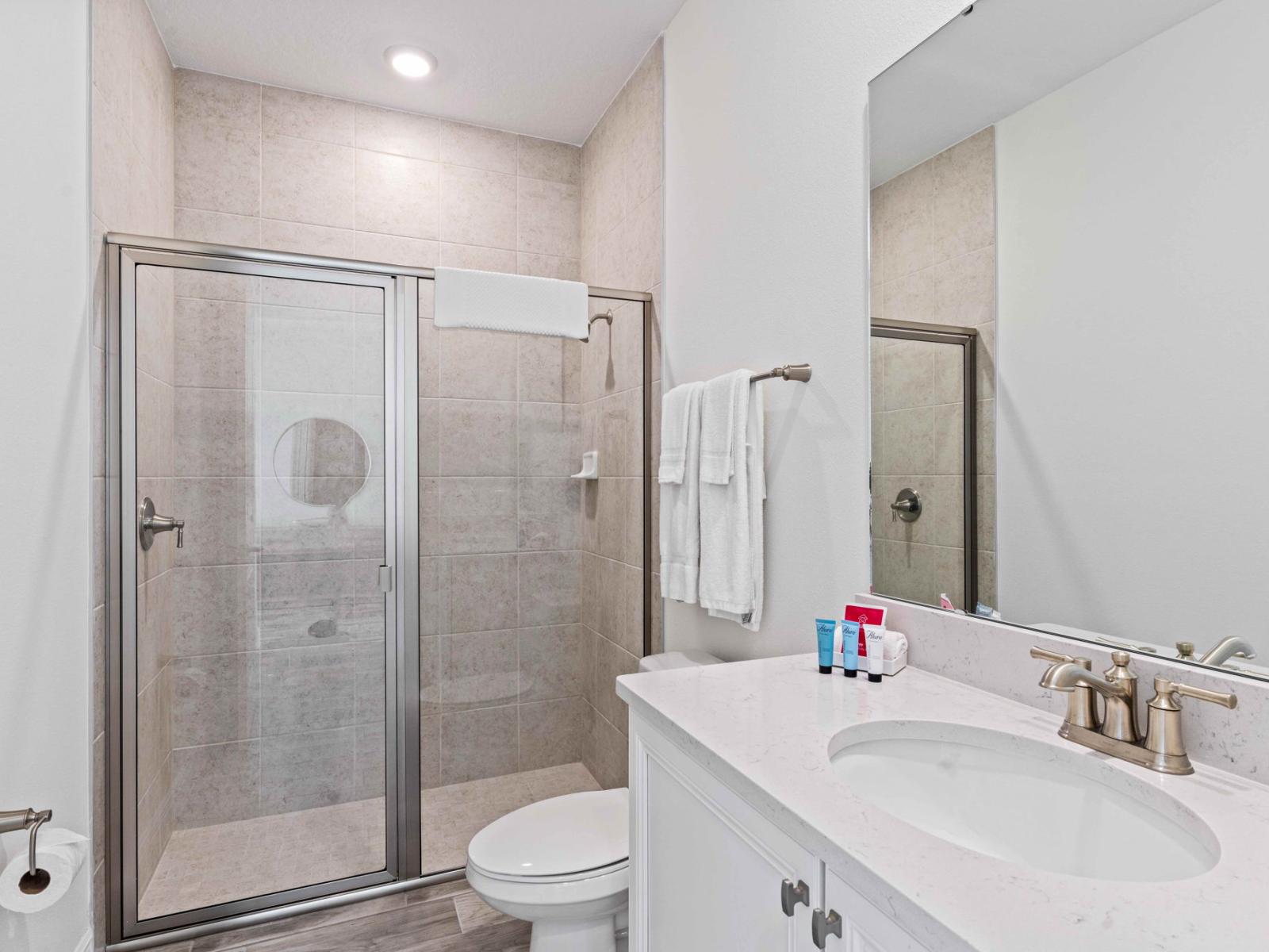 Lush bathroom of the cottage in Kissimmee Florida - Features a convenient walk-in shower - Ensuring a refreshing and invigorating experience - Chic vanity with large mirror