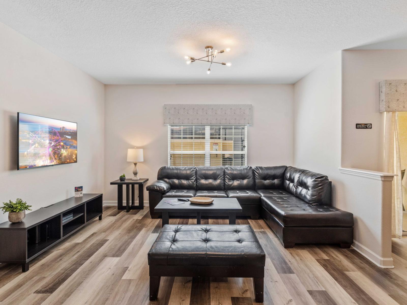 Modern living area of the townhouse in Kissimmee Florida - Relax in the stylish space with a sleek black couch - Smart TV and Netflix - Elegantly decorated space with a neutral color palette for a timeless appeal - Peaceful calming place