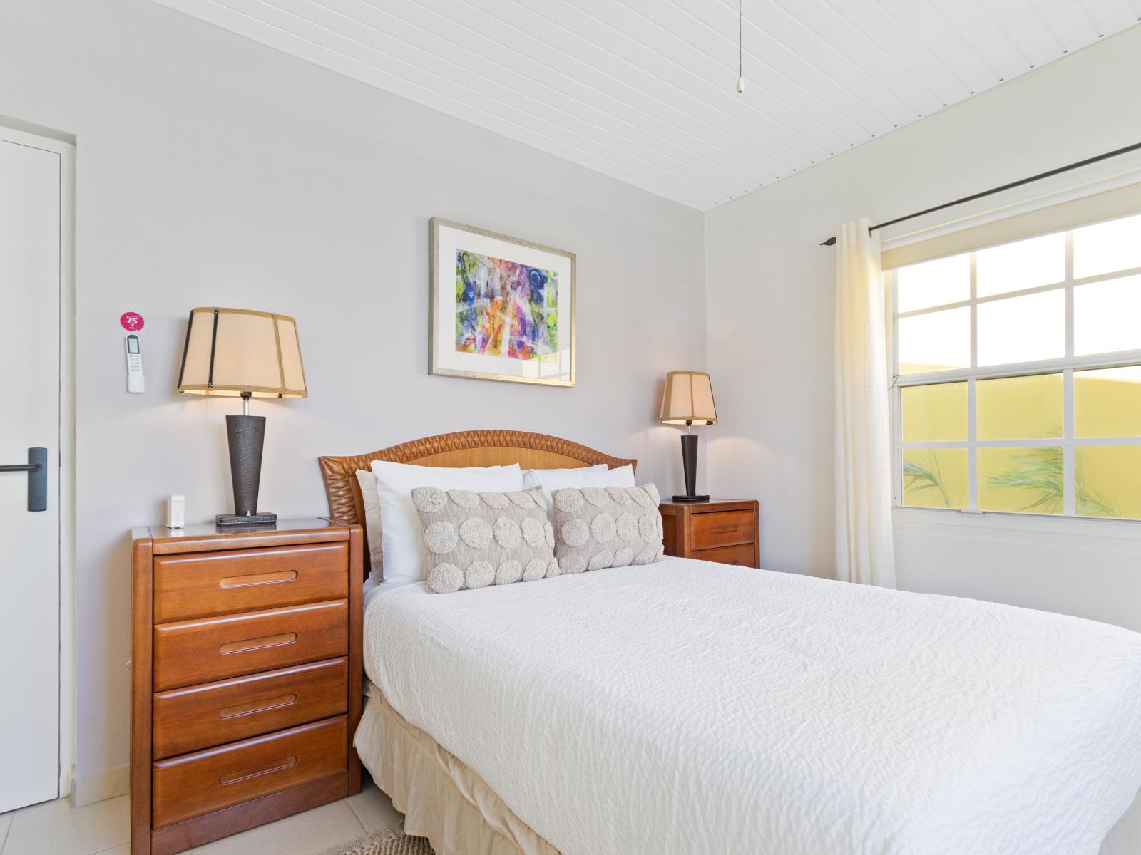 Sublime Bedroom of the 3BR House in Noord, Aruba - Cosy King size Bed - Stunning large window of the bedroom with mesmerising views  - Beautiful table Lamps - Elegantly decored room - Superb aesthetic wall painting