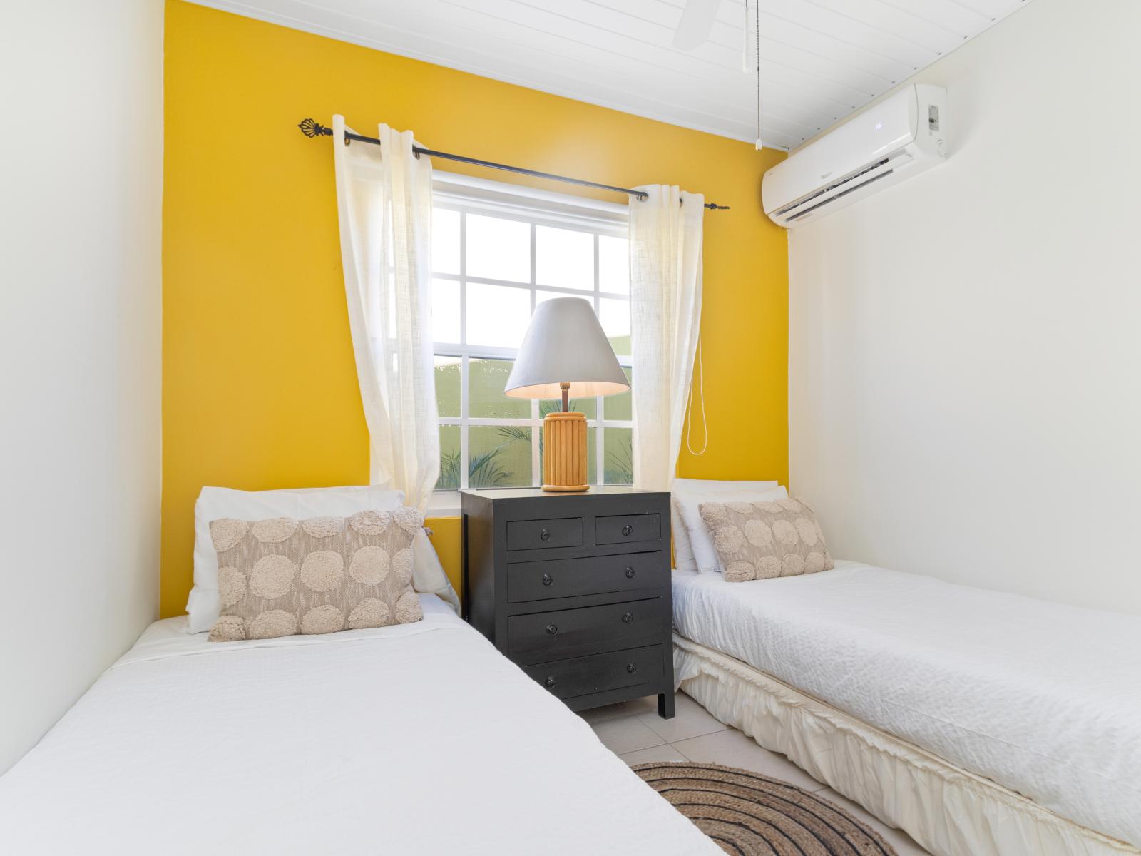 Imposing Bedroom of the 3BR House in Noord Aruba - Two Single bed and AC - Cozy retreat with a plush bed, perfect for relaxation - Minimalist decor, creating a clean and uncluttered sleeping space