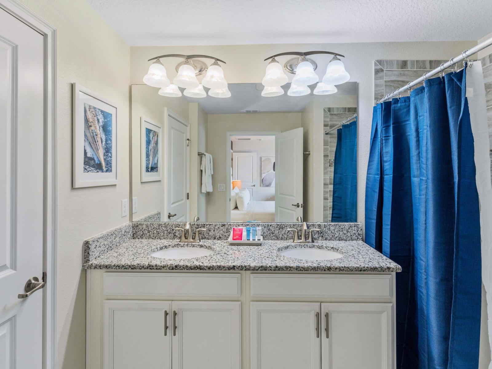 Sleek and Modern Oasis: Step into a sleek and modern oasis in our bathroom, complete with a vanity mirror, two sinks, and a luxurious walk-in shower-tub for your ultimate relaxation.