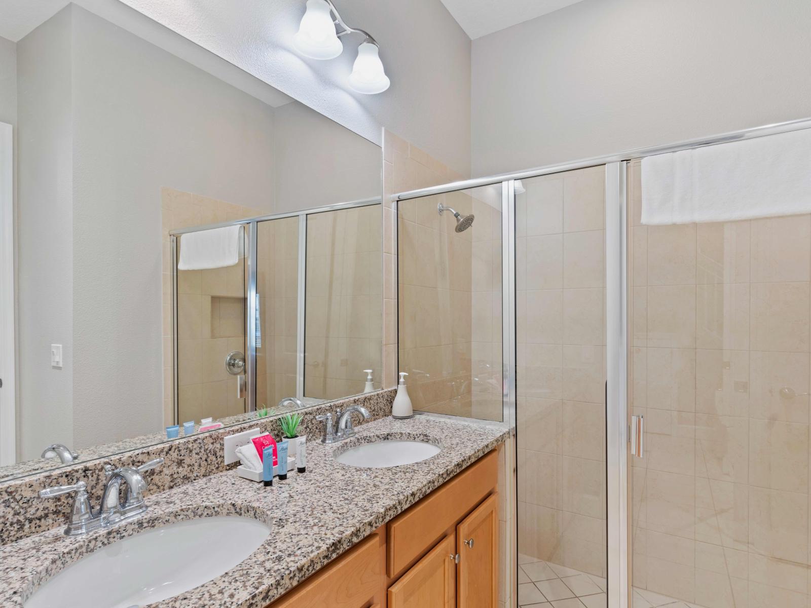 Polished Bathroom of the Townhouse in Davenport Florida - Chic design featuring a sleek dual vanity and upscale lighting - Seamless design featuring a glass-enclosed shower for a modern touch