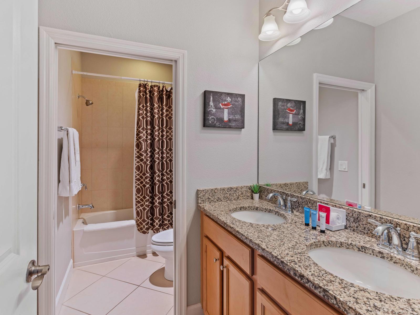 Chic Bathroom of the Townhouse in Davenport Florida - Bathtub and shower combo  - Lush dual vanity with large mirror - Clean space