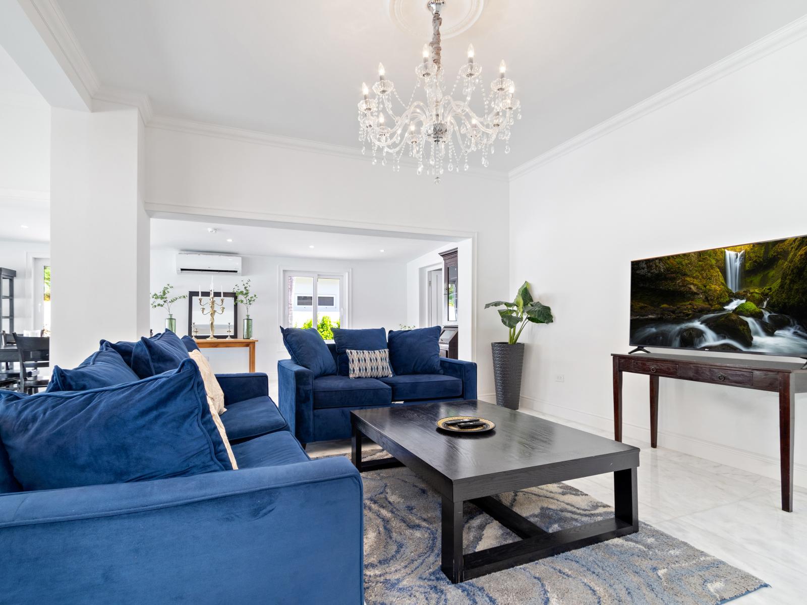 Experience elegance in our 5BR home's glamorous living area, curated for your comfort and enjoyment. Thoughtful lighting and stylish colors create a welcoming atmosphere, complemented by high ceilings that enhance the sense of space.