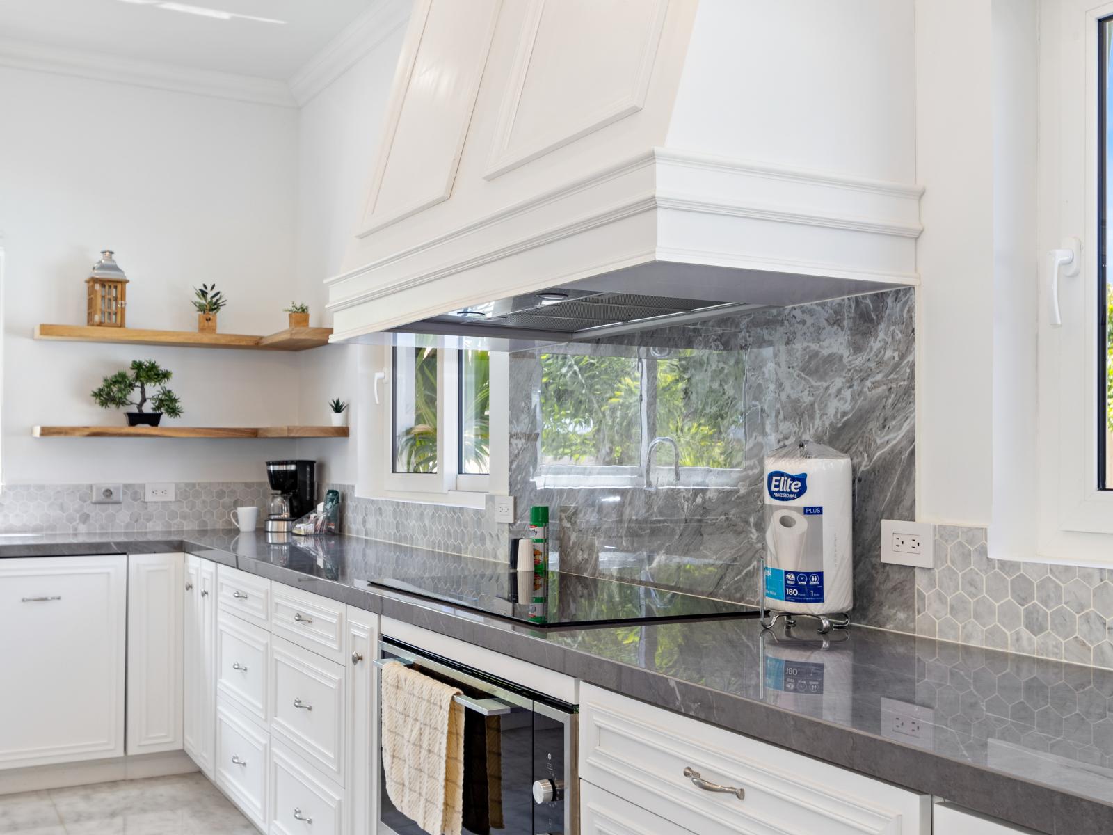 An oven and stove top complemented by a stylish marble backsplash, adding a touch of sophistication to the kitchen.