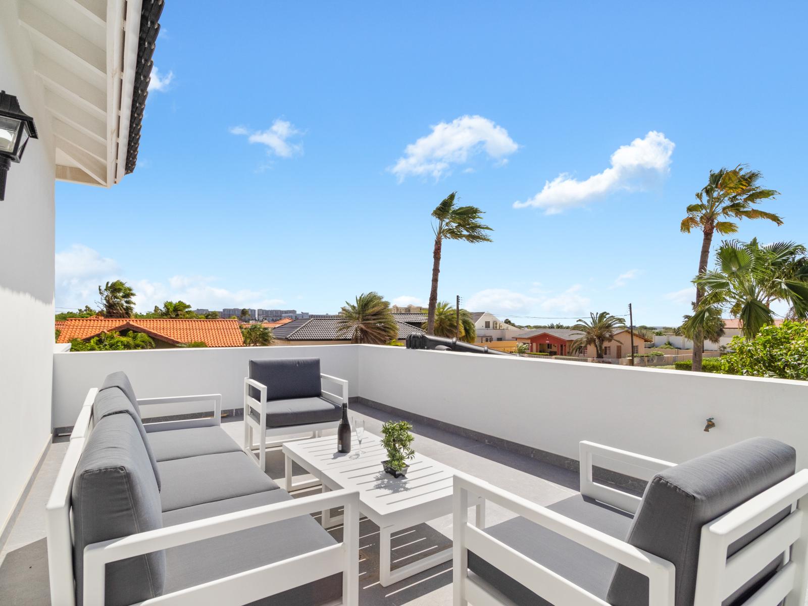 A balcony furnished with outdoor seating, providing a comfortable space to enjoy the open air.