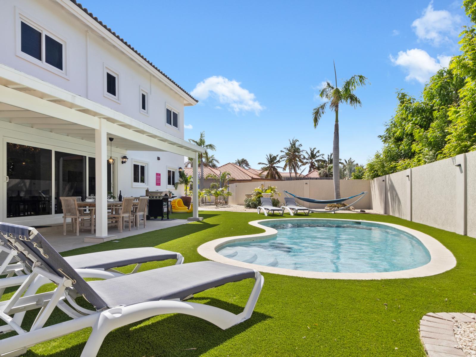 Poolside lounge chairs providing a comfortable vantage point with scenic views of beautiful palm trees.