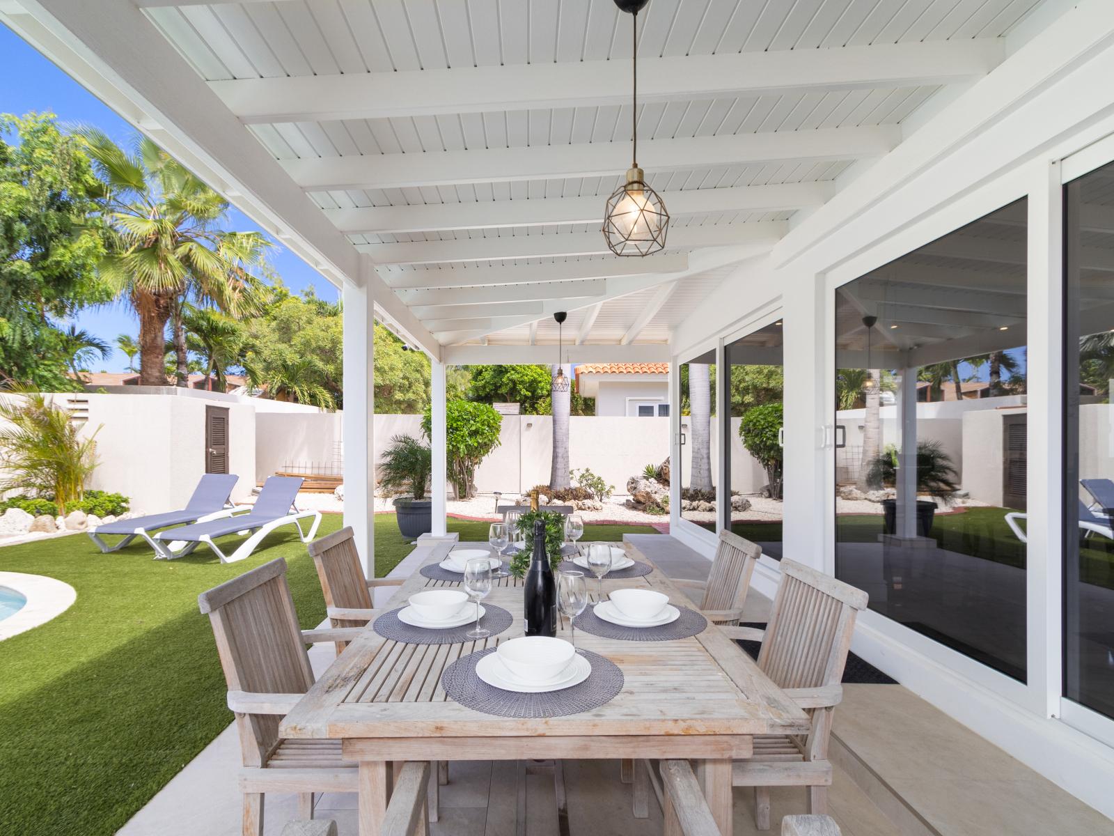 An outdoor dining table positioned alongside the pool, offering a picturesque setting for alfresco meals and leisure.