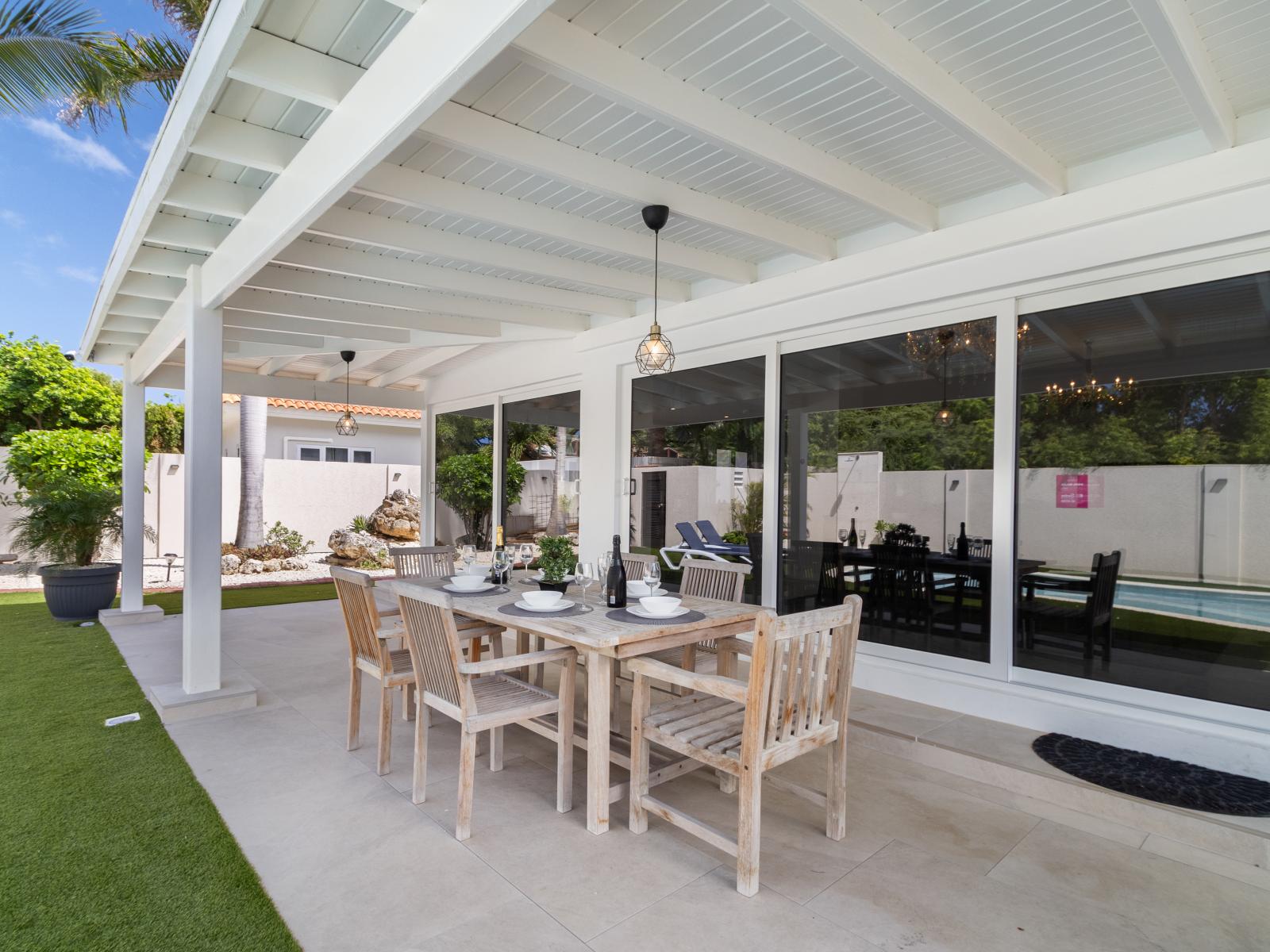 An outdoor dining table set up on the backyard patio, providing a charming spot for open-air dining and relaxation.