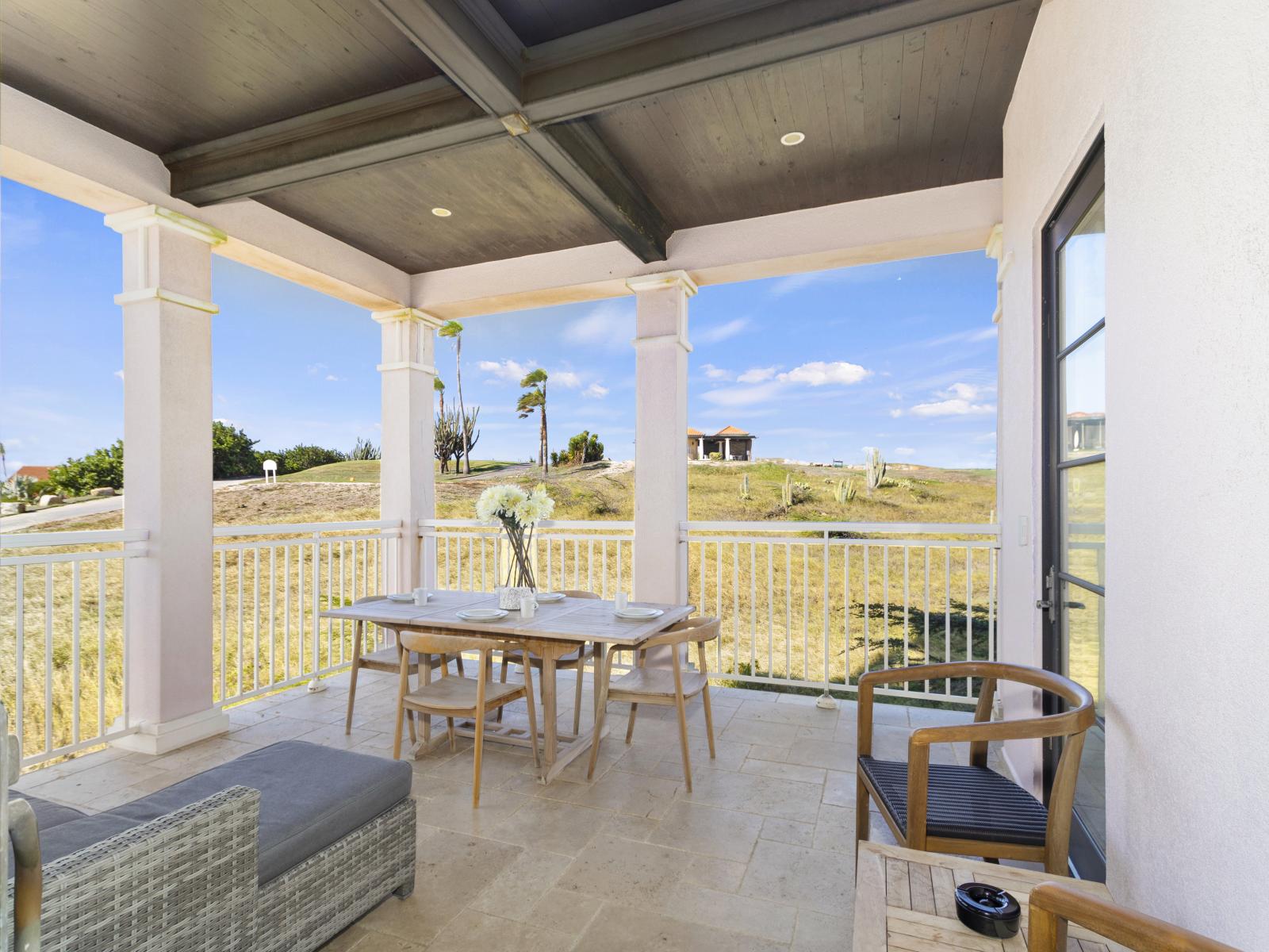 Lounge area and a dining table with a picturesque view of the adjacent golf course.