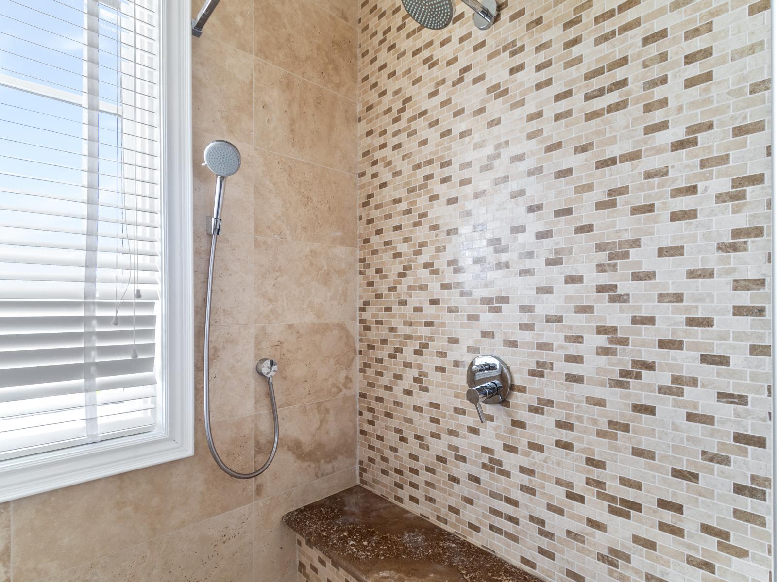 Bathroom 2 Offers a Spacious Shower with a Bench.