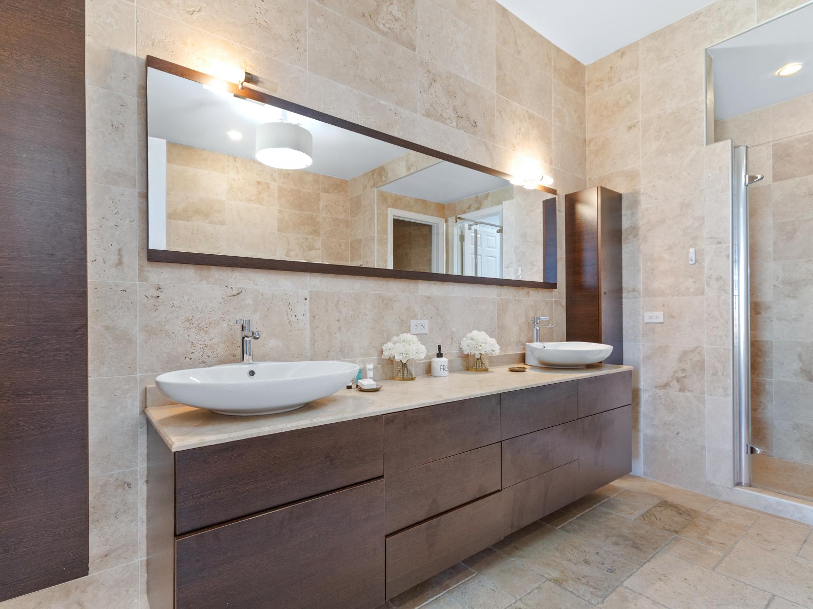 Indulge in the third bedroom's luxurious bathroom, featuring a walk-in shower, dual sinks, and a spacious vanity