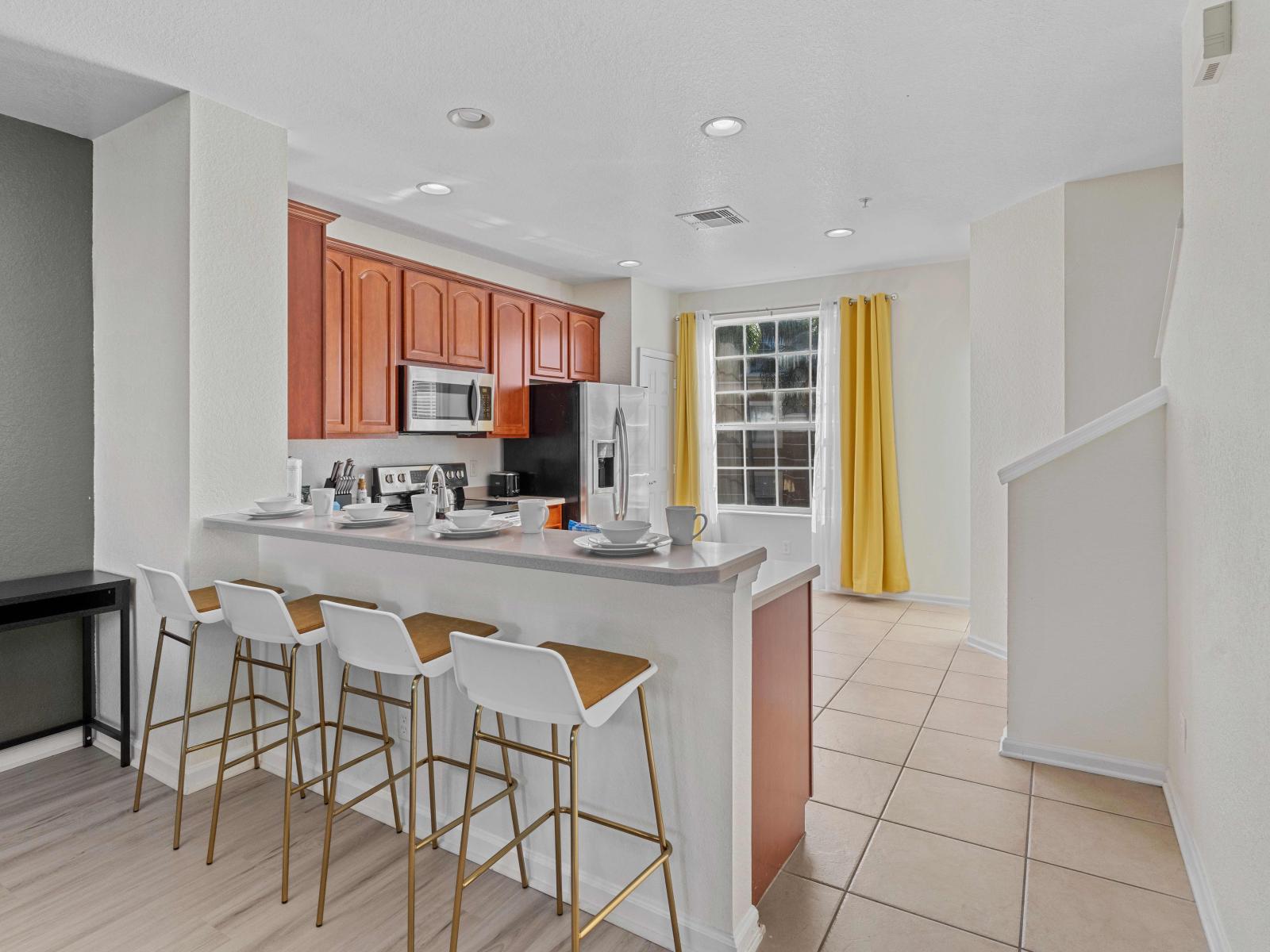 Step into the Modern Culinary Haven of the townhouse at Vista Cay resort in Orlando. - Expose your inner chef in our spacious kitchen, featuring plenty plenty space. - Availability of high chairs at the breakfast bar - Elegant lighting