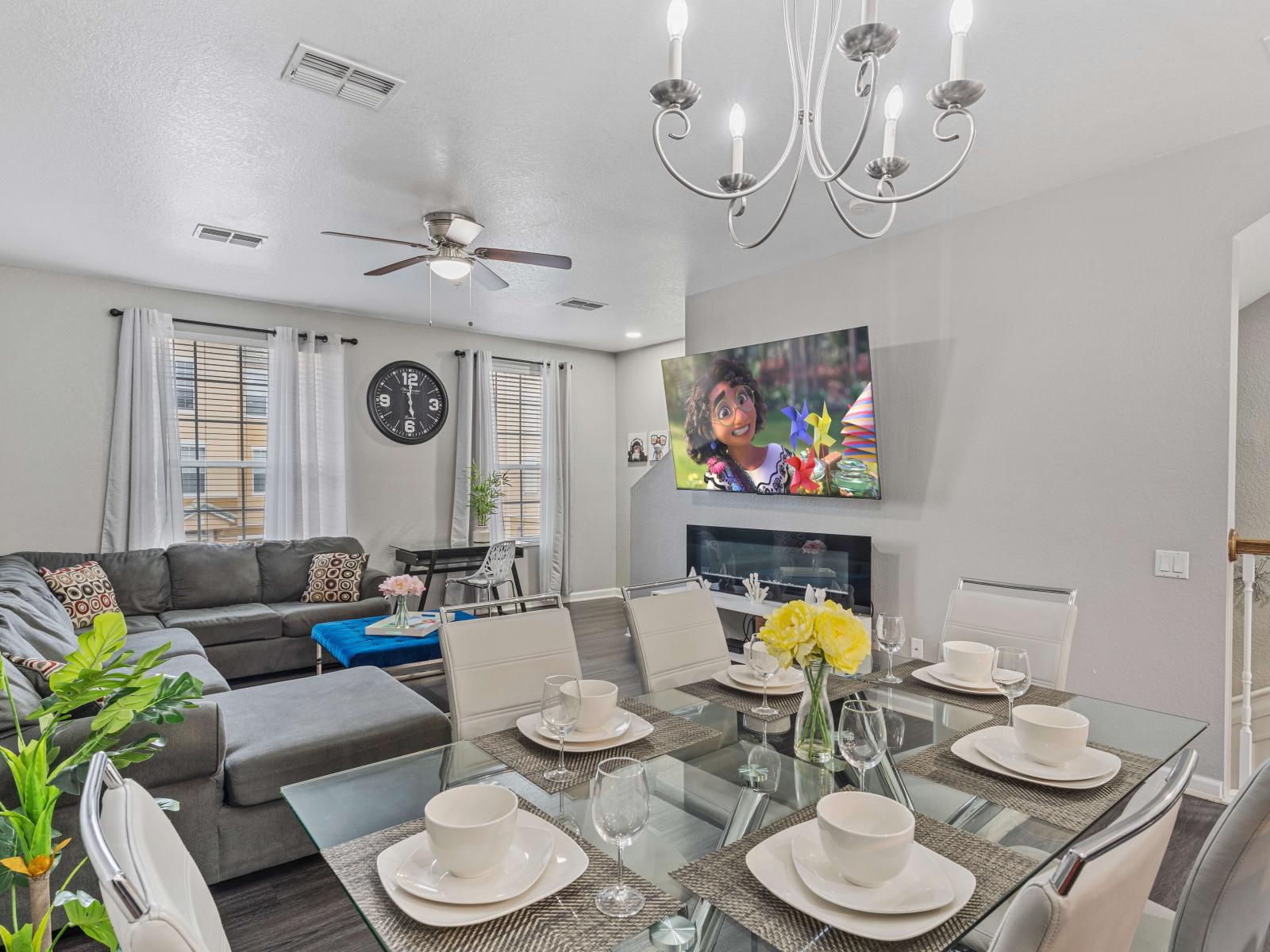 Dining area and living room with indoor fireplace and large smart TV