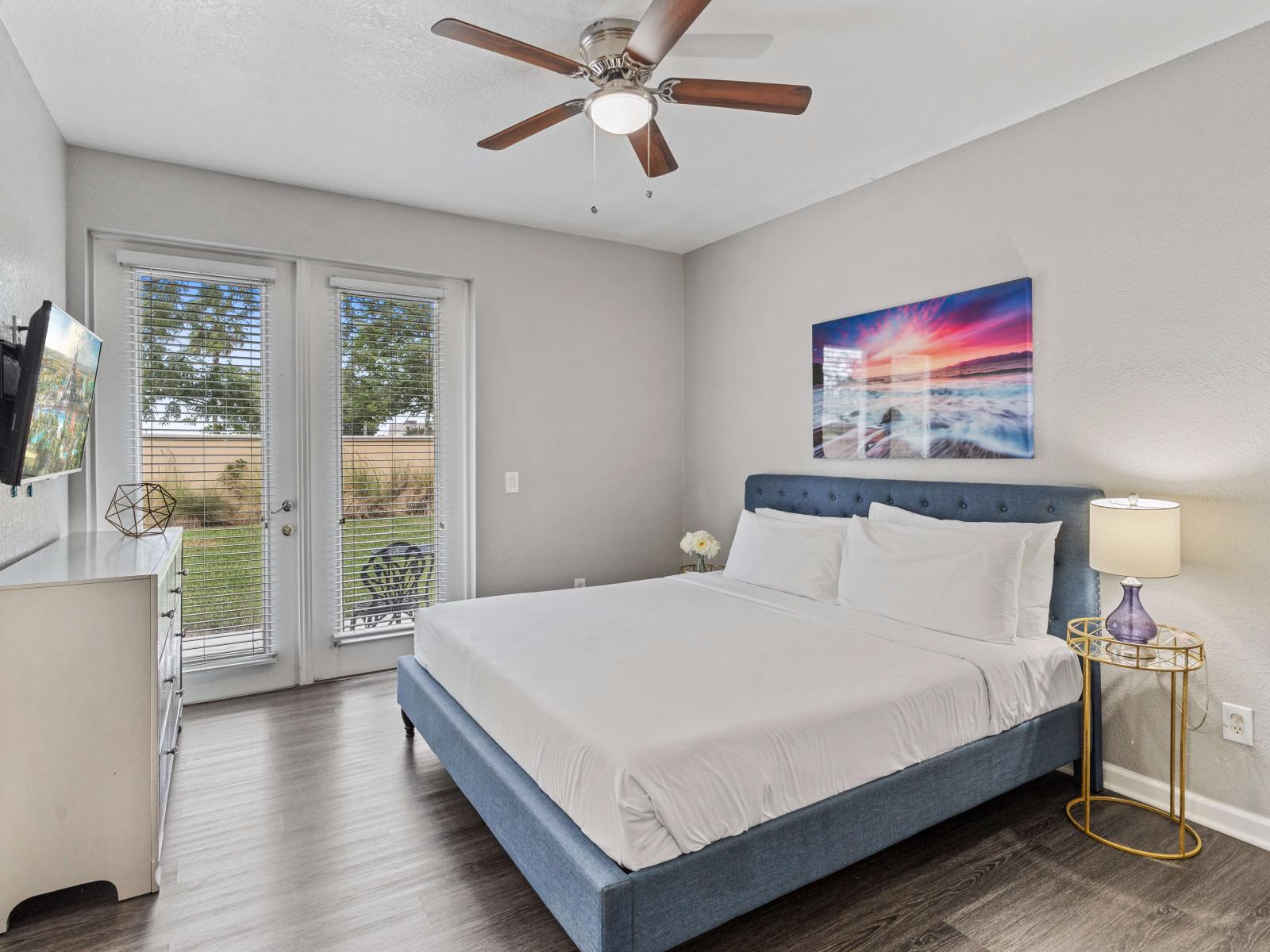 - Magnificent bedroom of the townhouse in Orlando Florida - Plush double bed to relax - Entertainment hub with a Smart TV - Bedroom with a cozy ambiance - Well-appointed door that leads to the outdoor patio - Elegantly wooden furnished floor