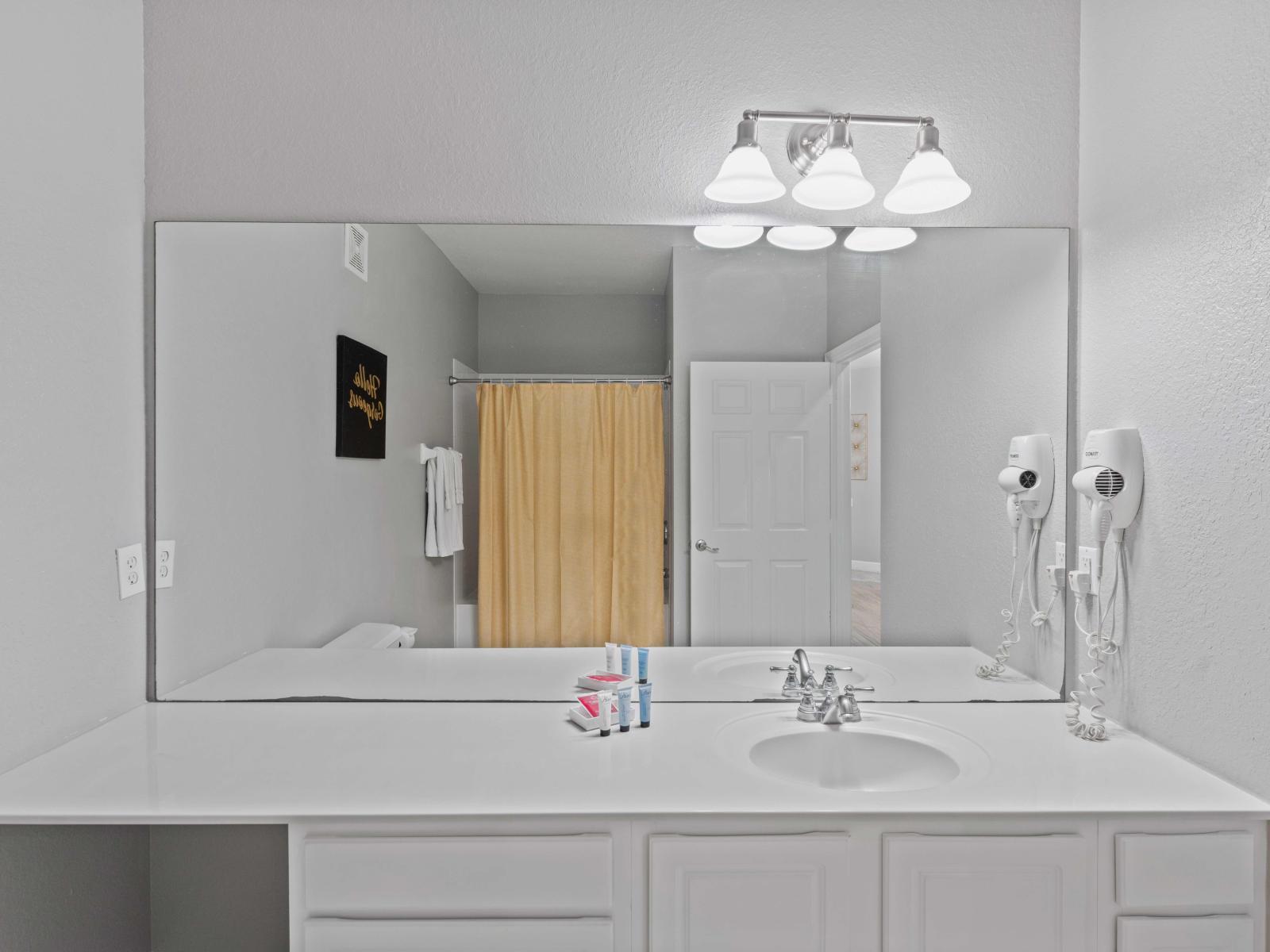 Lavish Bathroom of the condo in Orlando - Chic design featuring a sleek vanity and upscale lighting - Thoughtful storage solutions with stylish cabinets - Attention to detail, from the elegant tiles to the faucets