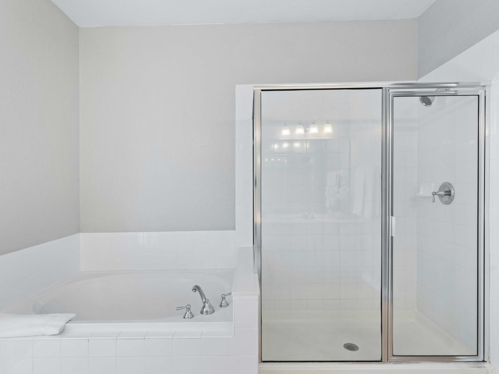 Step into luxury with Bathroom 1, featuring a sumptuous tub, convenient walk-in shower, and elegant double vanity. Designed for pampering, it offers a serene escape for relaxation and rejuvenation.