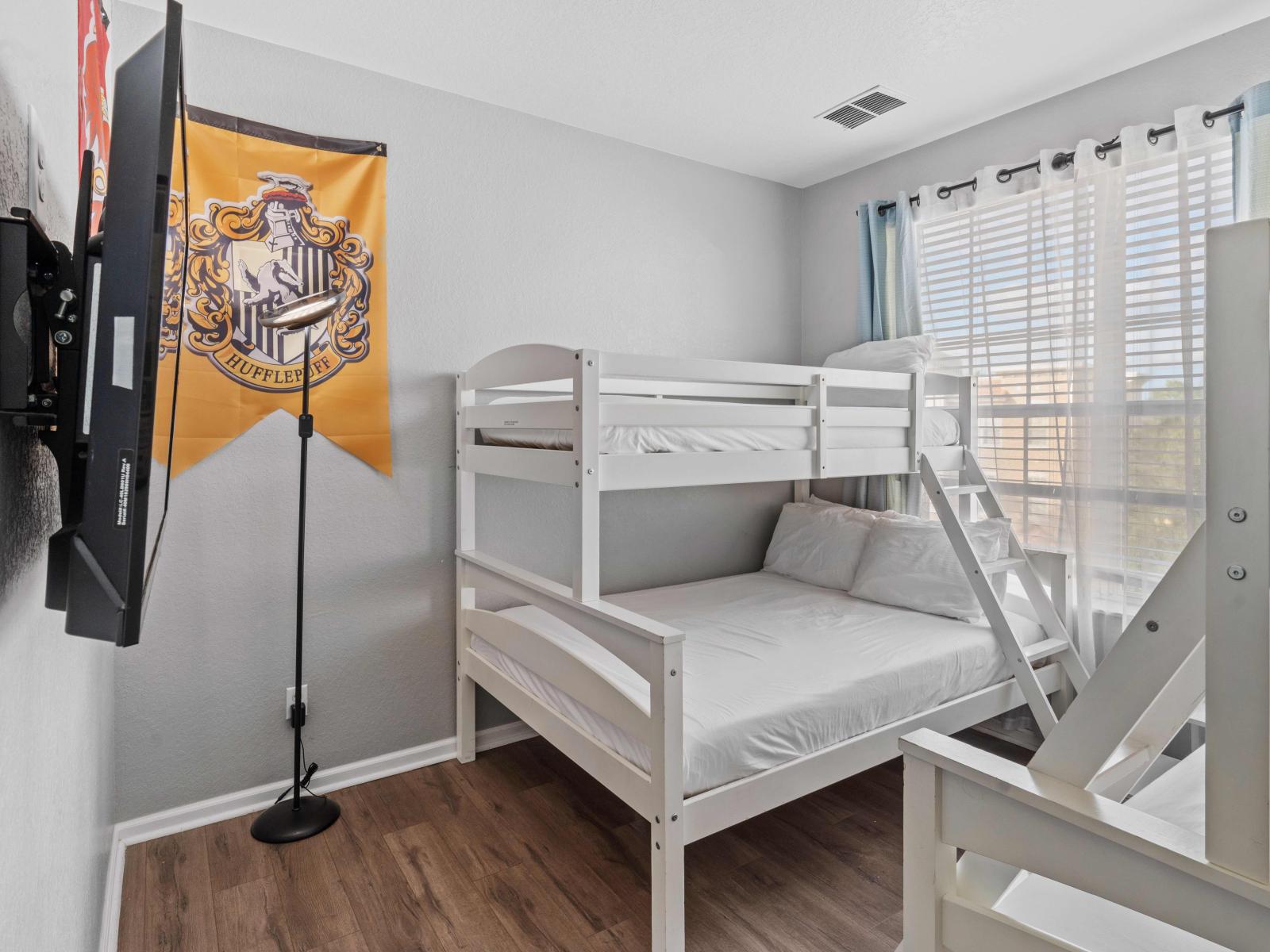 Cozy Bunk Retreat: Bedroom 2 offers the perfect sleeping haven with two single over double bunk beds, providing ample space for a comfortable night's rest for multiple guests.