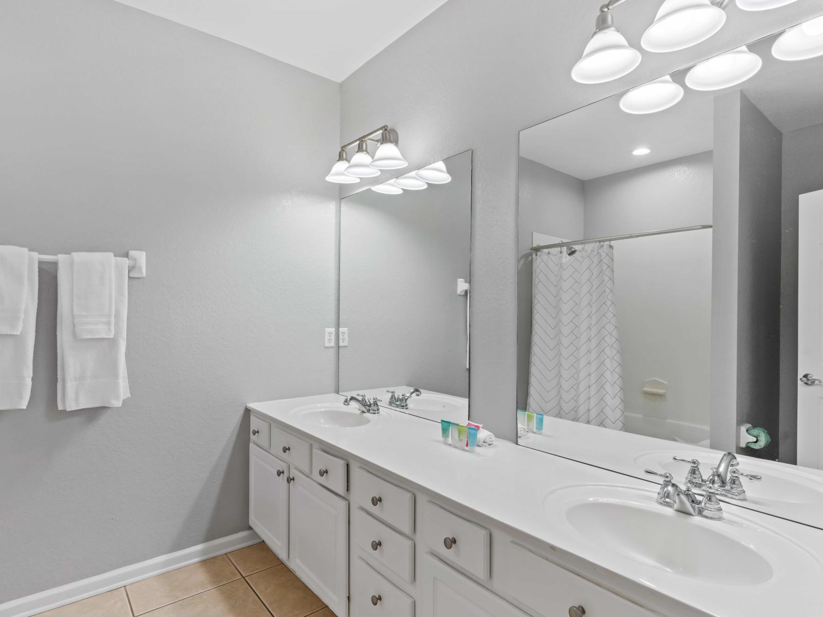 Refined Comfort: En-suite Bathroom 2 at Vista Cay Resort features a double vanity and a luxurious tub/shower combination, offering guests a refined retreat where modern amenities and elegant design converge for moments of relaxation and indulgence.