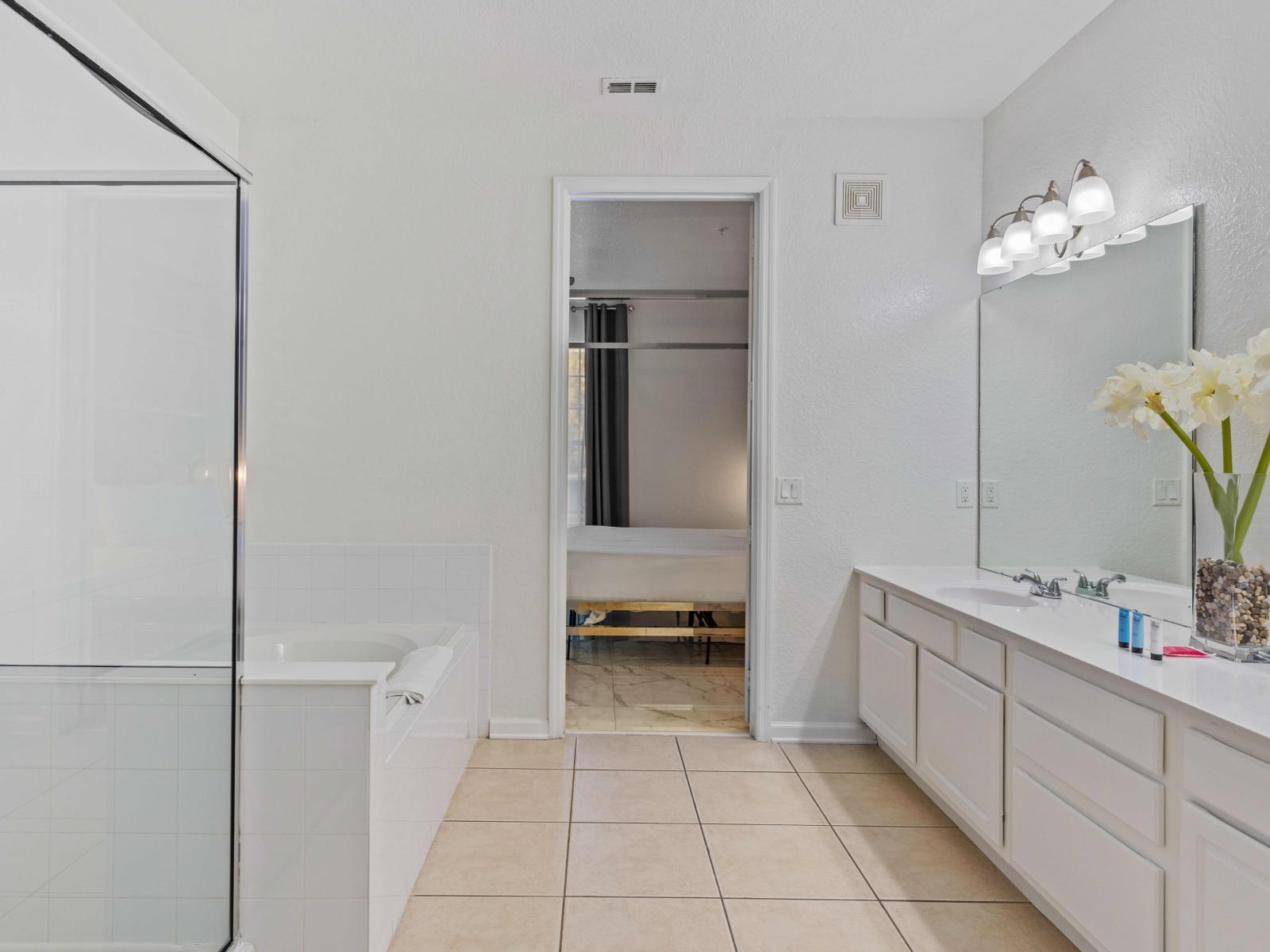 This expansive bathroom boasts double sinks, a convenient walk-in shower, and a luxurious bathtub, offering the ultimate relaxation and rejuvenation experience.