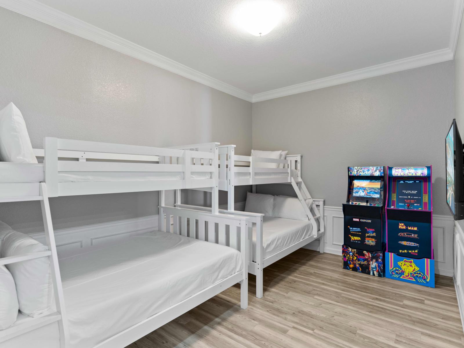 Bonus room with two bunk single over double bunk beds and arcade games