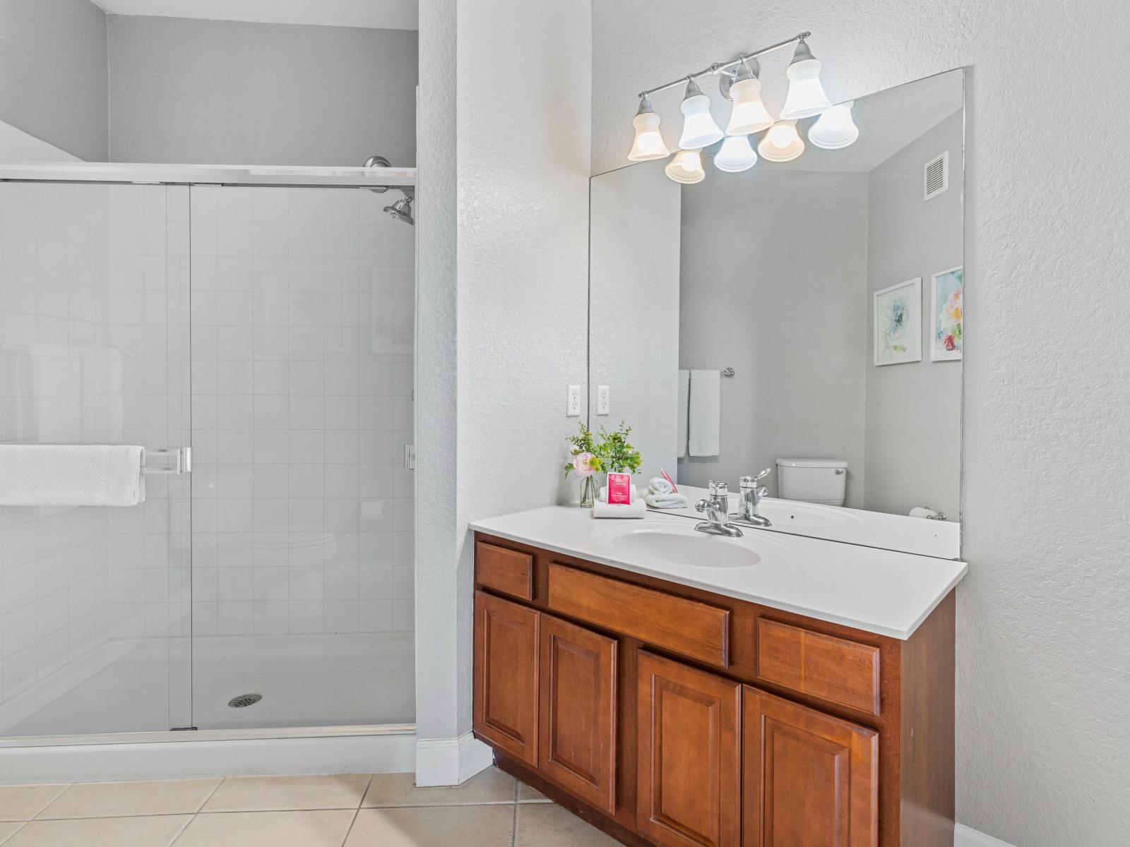 Sleek faucets, and contemporary lighting, provides a luxurious and stylish experience - Plenty of storage options in the bathroom including cabinets, shelves, and drawers - Bathroom offers privacy and in the glass-covered shower area