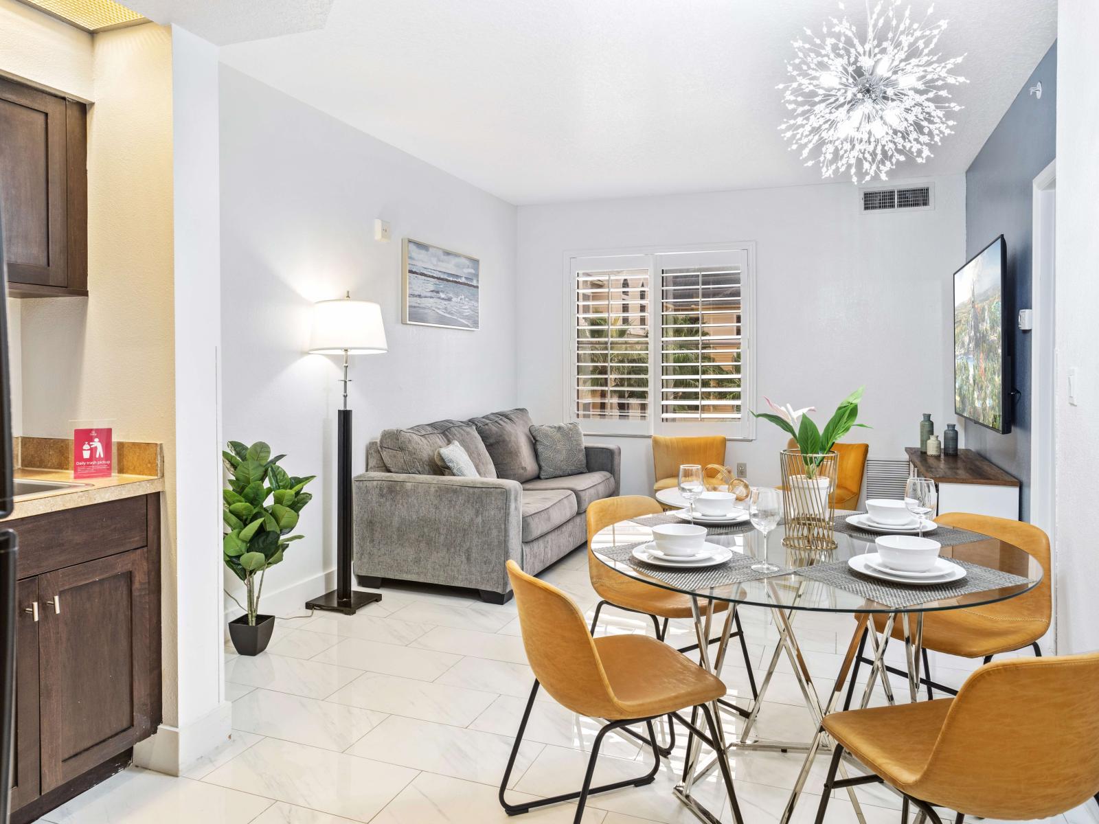 Living room with large smart TV, sleeper sofa and kitchen