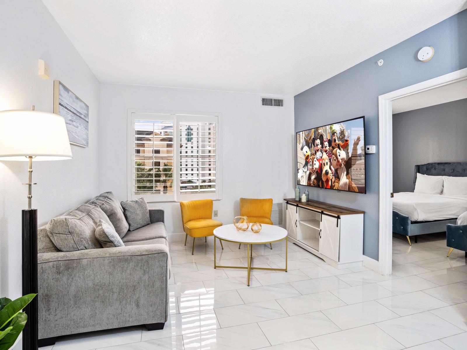 Living room with large smart TV, sleeper sofa and kitchen